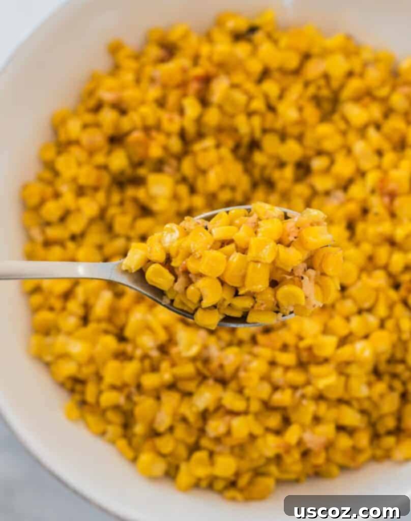 Crispy Roasted Frozen Corn 3 A spoon scooping roasted corn from a bowl, showing crispy edges