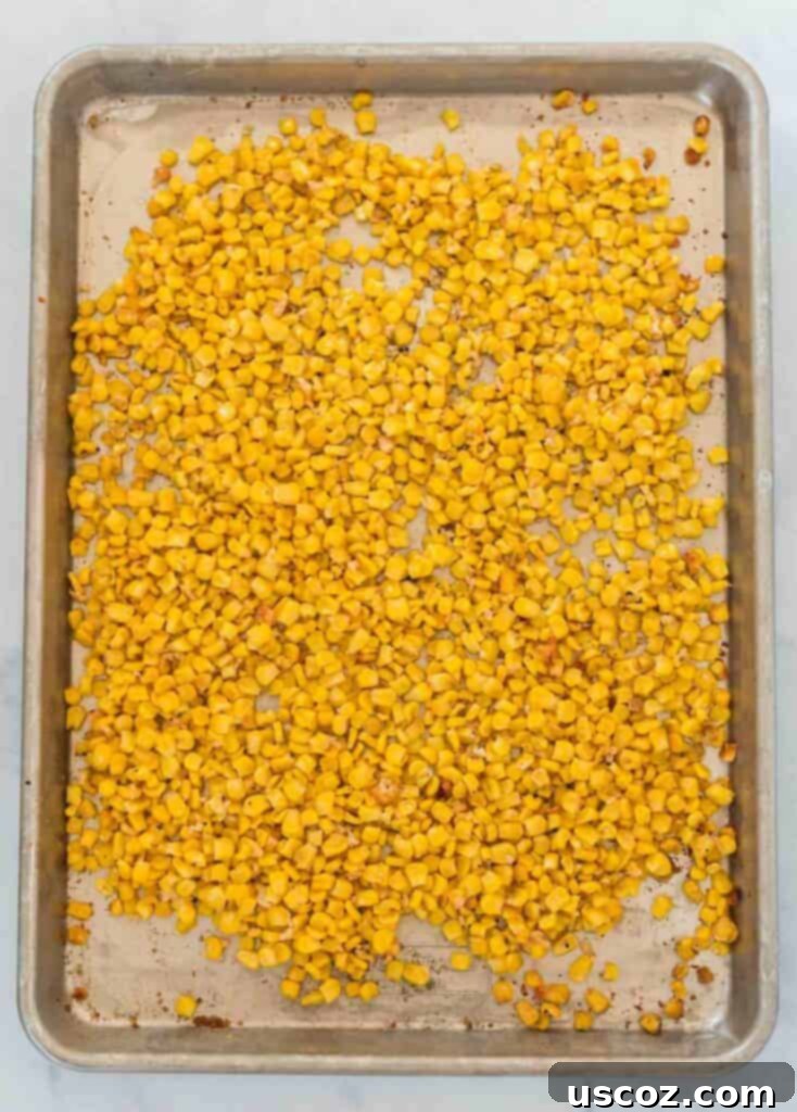 Crispy Roasted Frozen Corn 4 Close-up of roasted corn kernels with seasonings on a baking sheet