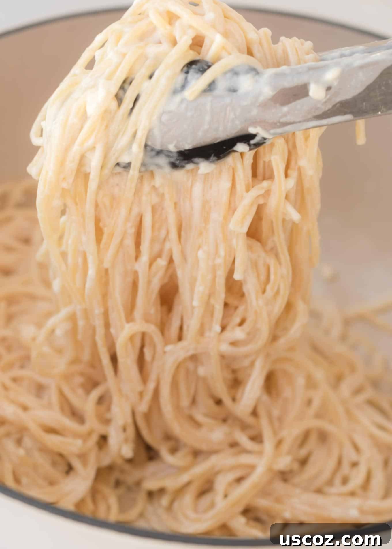 Velvety Cream Cheese Pasta 9 Close-up of a serving of cream cheese spaghetti, showing the noodles coated in a rich, white sauce.