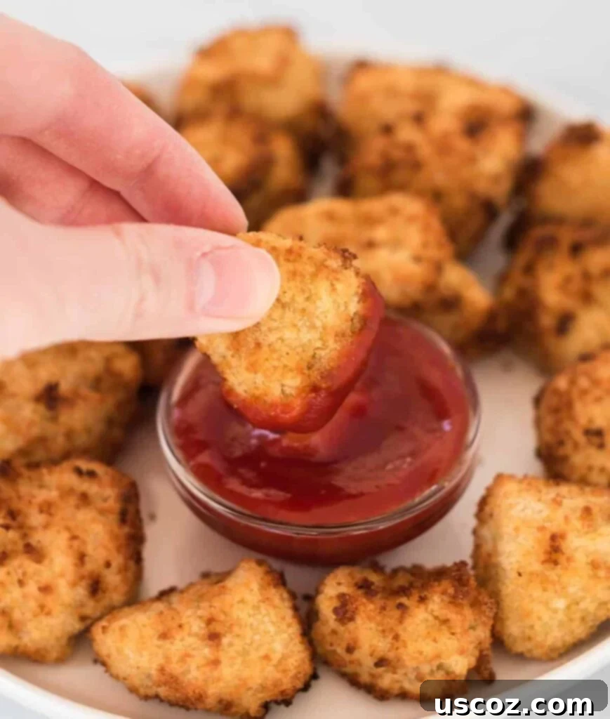 Crispy Air Fryer Tofu Nuggets 2 air fryer tofu nugget being dipped into ketchup