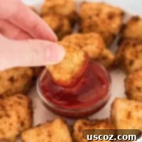 Crispy Air Fryer Tofu Nuggets 12 air fryer tofu nugget being dipped into ketchup