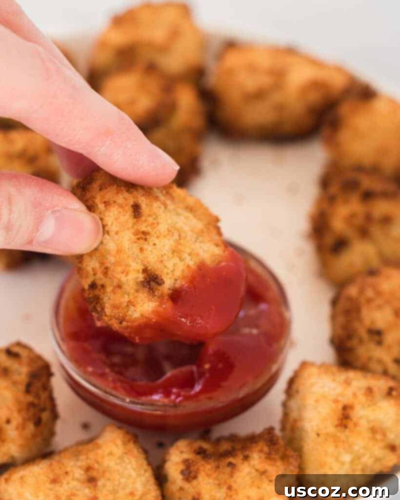 Crispy Air Fryer Tofu Nuggets 8 air fryer tofu nugget being dipped into ketchup