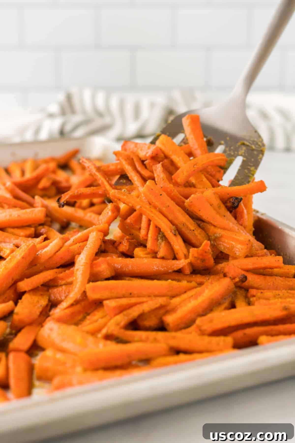 The Ultimate Roasted Carrots 2 spatula taking a serving of roasted carrots
