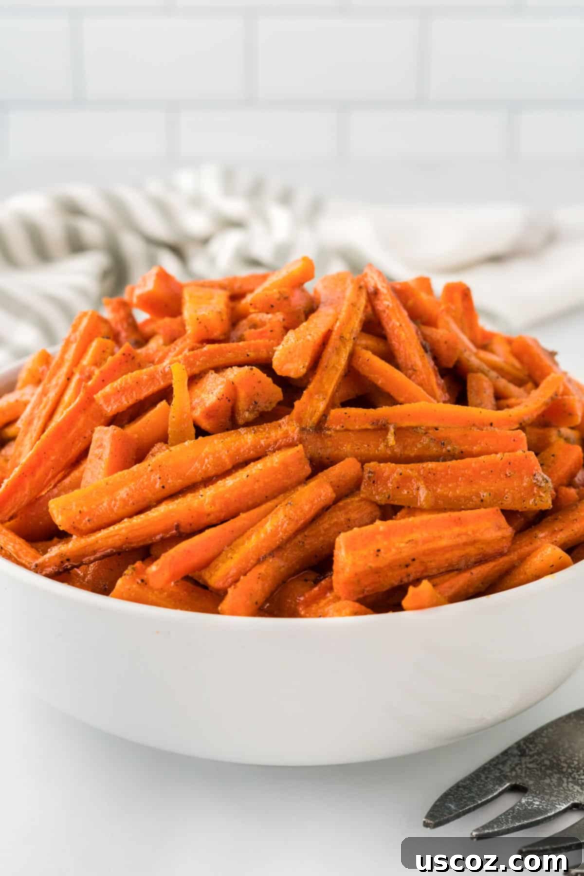 The Ultimate Roasted Carrots 12 roasted carrots in a white serving bowl
