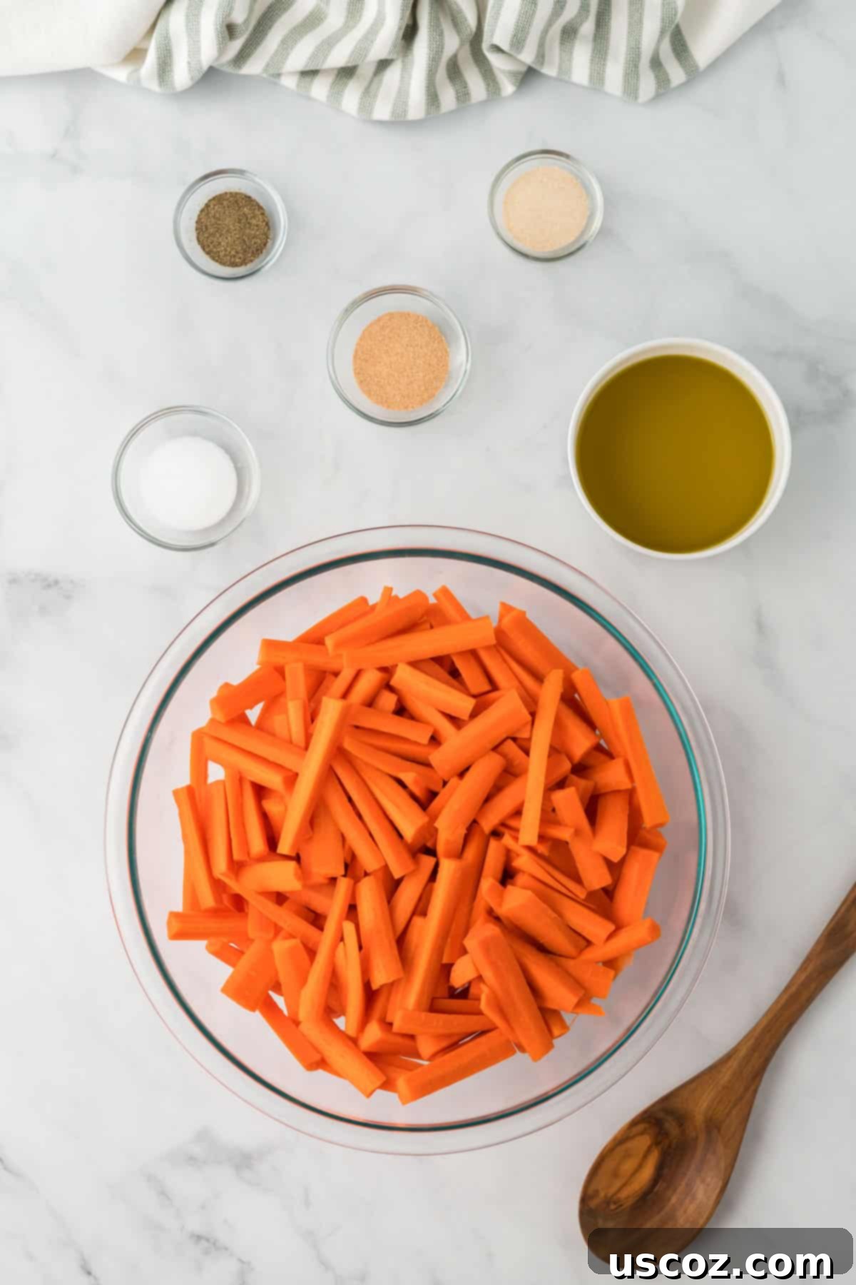 The Ultimate Roasted Carrots 5 cut up carrots in a bowl with olive oil and spices in bowls next to it