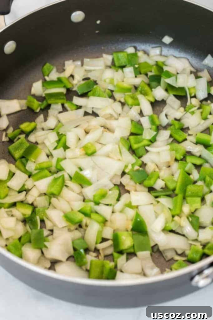 Ultimate Plant-Based Enchiladas 3 white onion and bell pepper in a skillet
