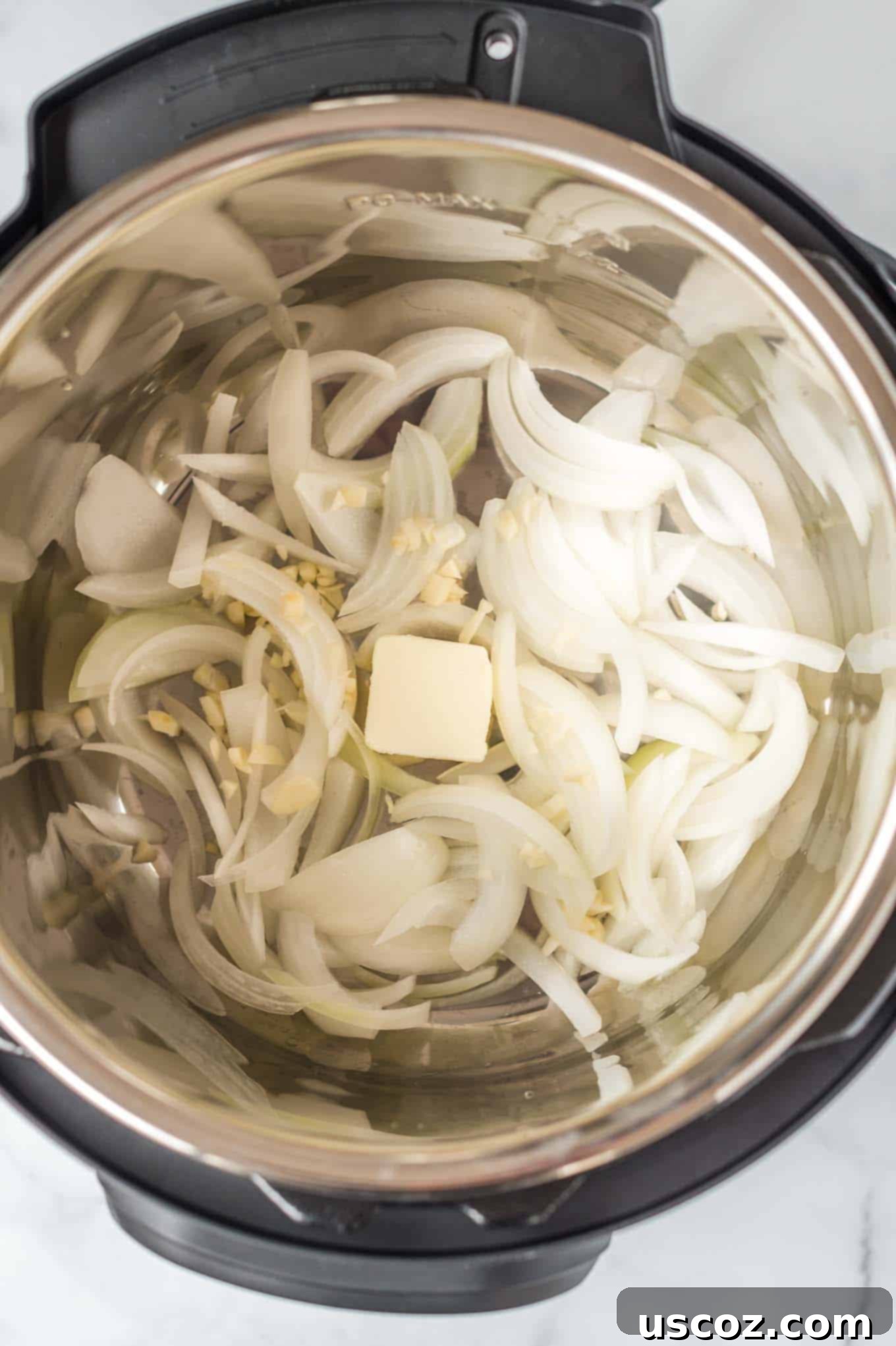 Savory Instant Pot Cabbage 5 Sliced onions, minced garlic, and butter sautéing in an Instant Pot