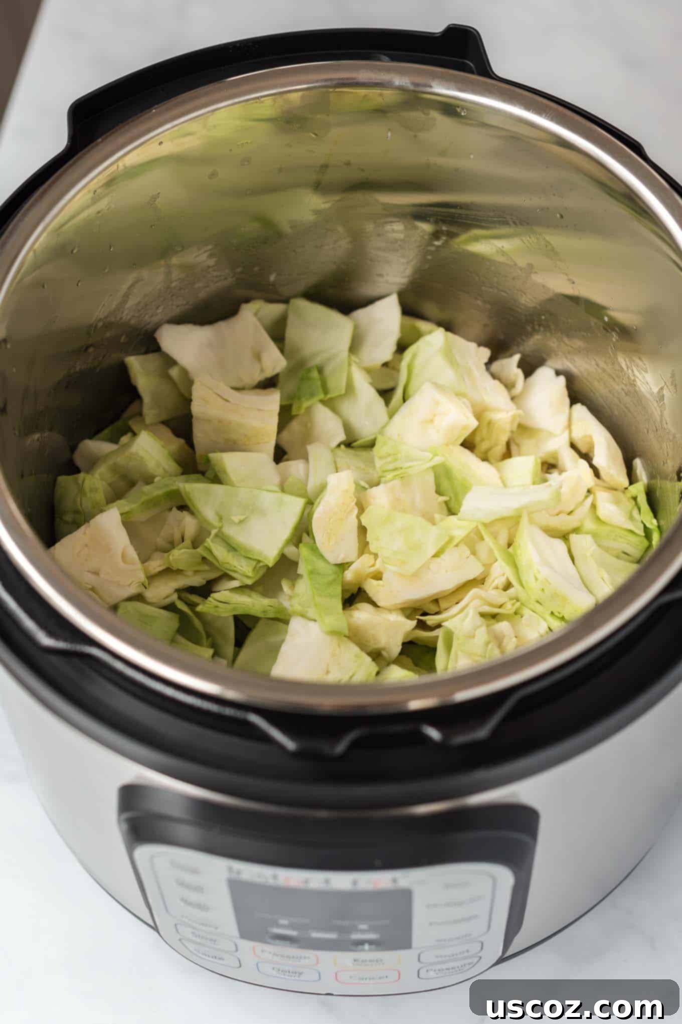 Savory Instant Pot Cabbage 6 Chopped cabbage layered over broth and butter in an Instant Pot before cooking