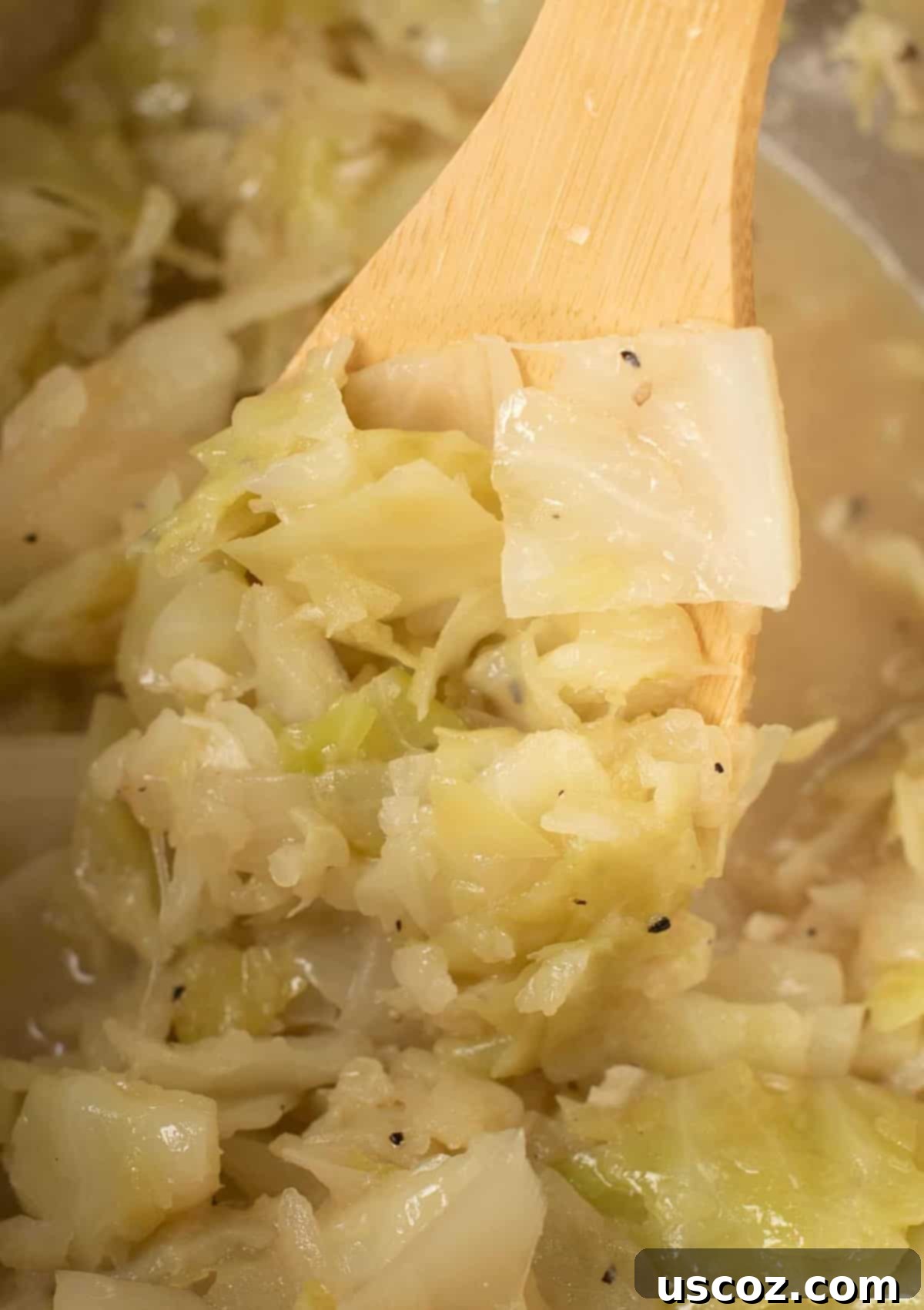 Savory Instant Pot Cabbage 7 A slotted spoon serving buttery Instant Pot cabbage from the pot
