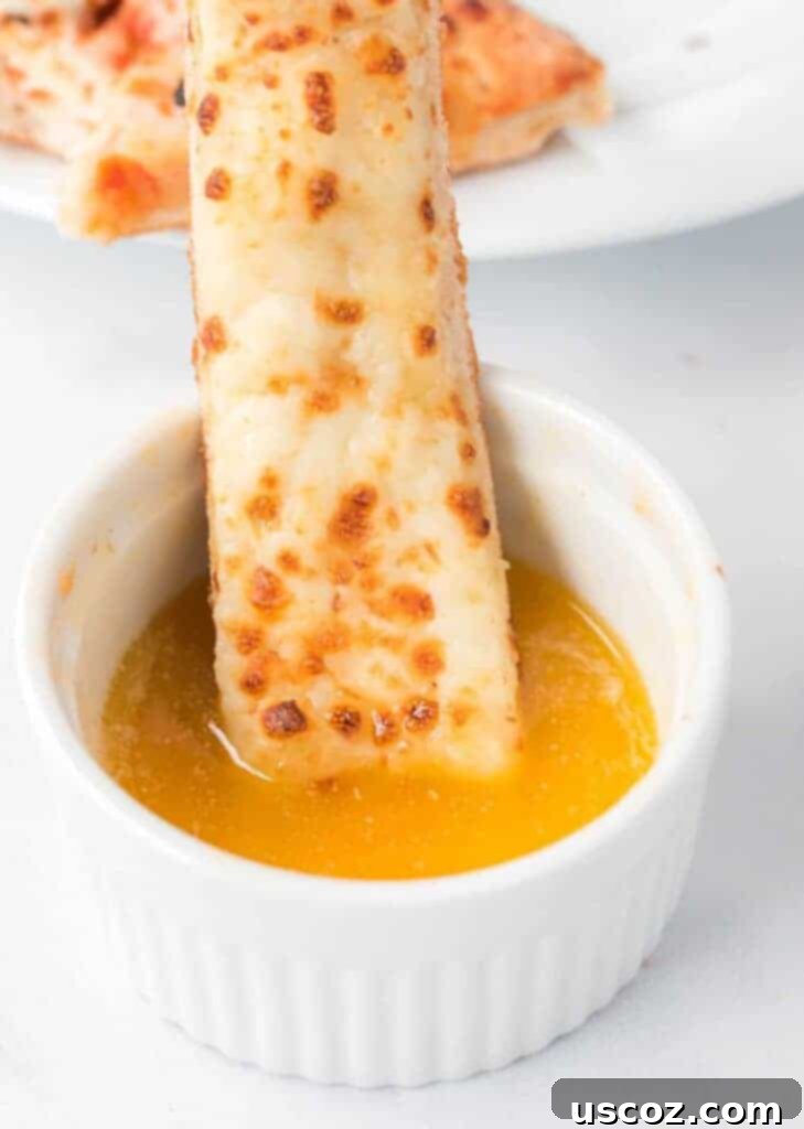 Flavorful Garlic Dip 2 Cheese stick being dipped in homemade Papa John's style garlic sauce