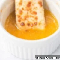 Flavorful Garlic Dip 7 cheese stick being dipped in garlic sauce