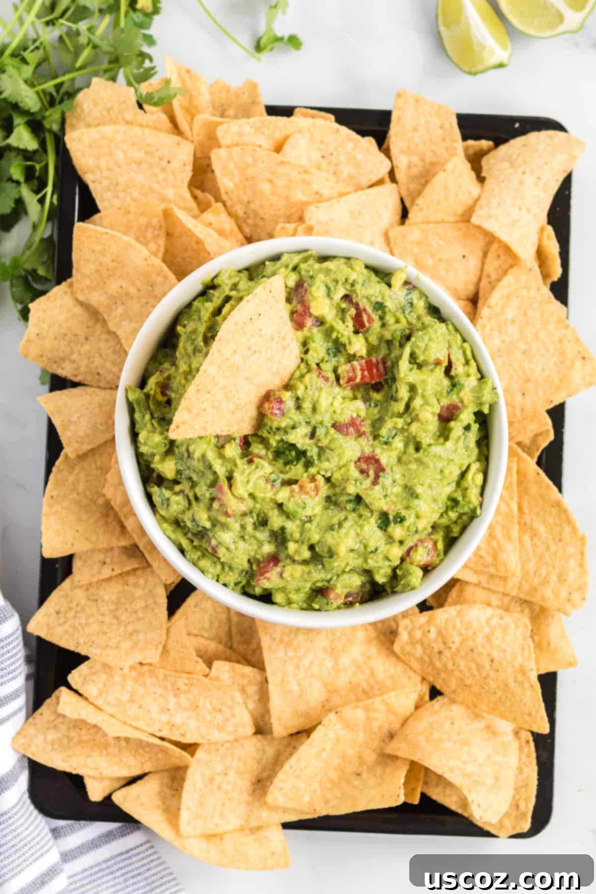 Your New Favorite Guacamole Recipe 6 Close-up of a serving bowl filled with fresh guacamole, surrounded by tortilla chips, ready for a party.