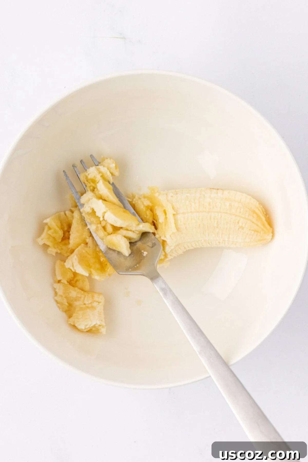 Power-Packed Overnight Oats 5 mashing a banana in a bowl with a fork