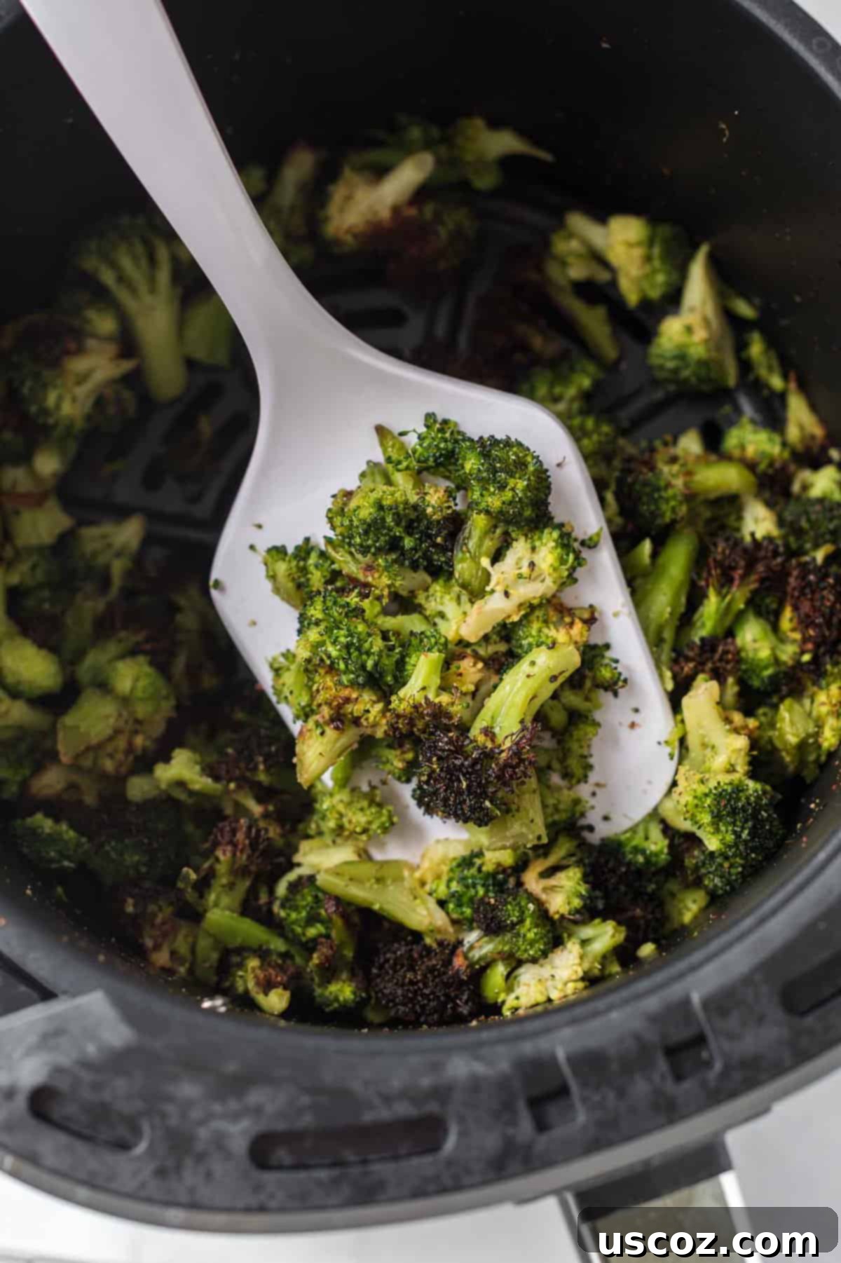 Crispy Air Fryer Frozen Broccoli 2 a white spatula with a scoop of roasted broccoli