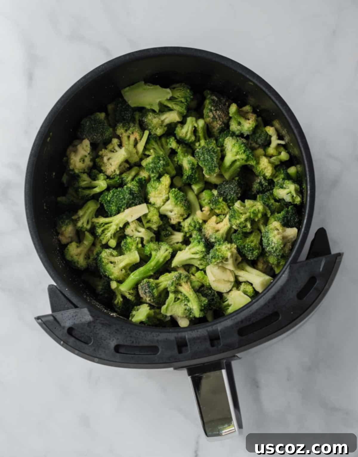 Crispy Air Fryer Frozen Broccoli 3 frozen broccoli florets in an air fryer basket