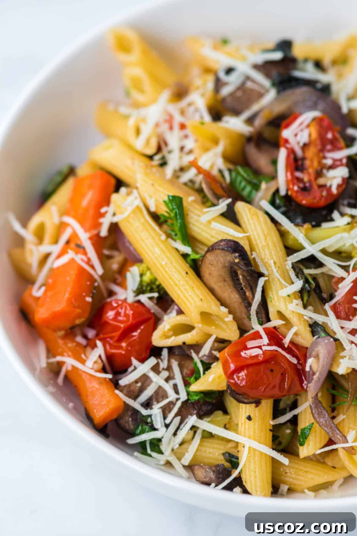 Hearty Roasted Veggie Pasta 3 roasted vegetable pasta in a white bowl topped with parmesan cheese