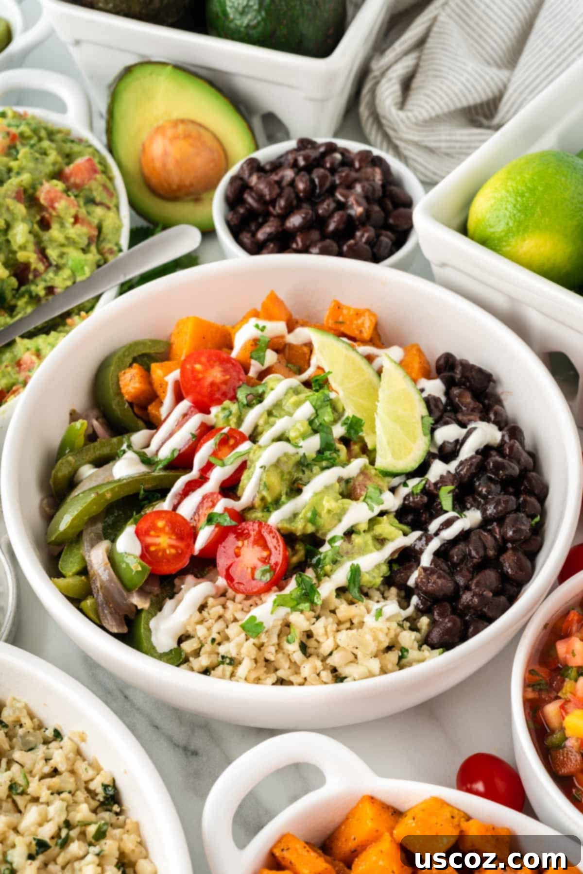 Zesty Cilantro Lime Cauliflower Rice 11 A vibrant cauliflower rice burrito bowl featuring cilantro lime cauliflower rice, black beans, colorful fajita vegetables, roasted sweet potatoes, and creamy guacamole.
