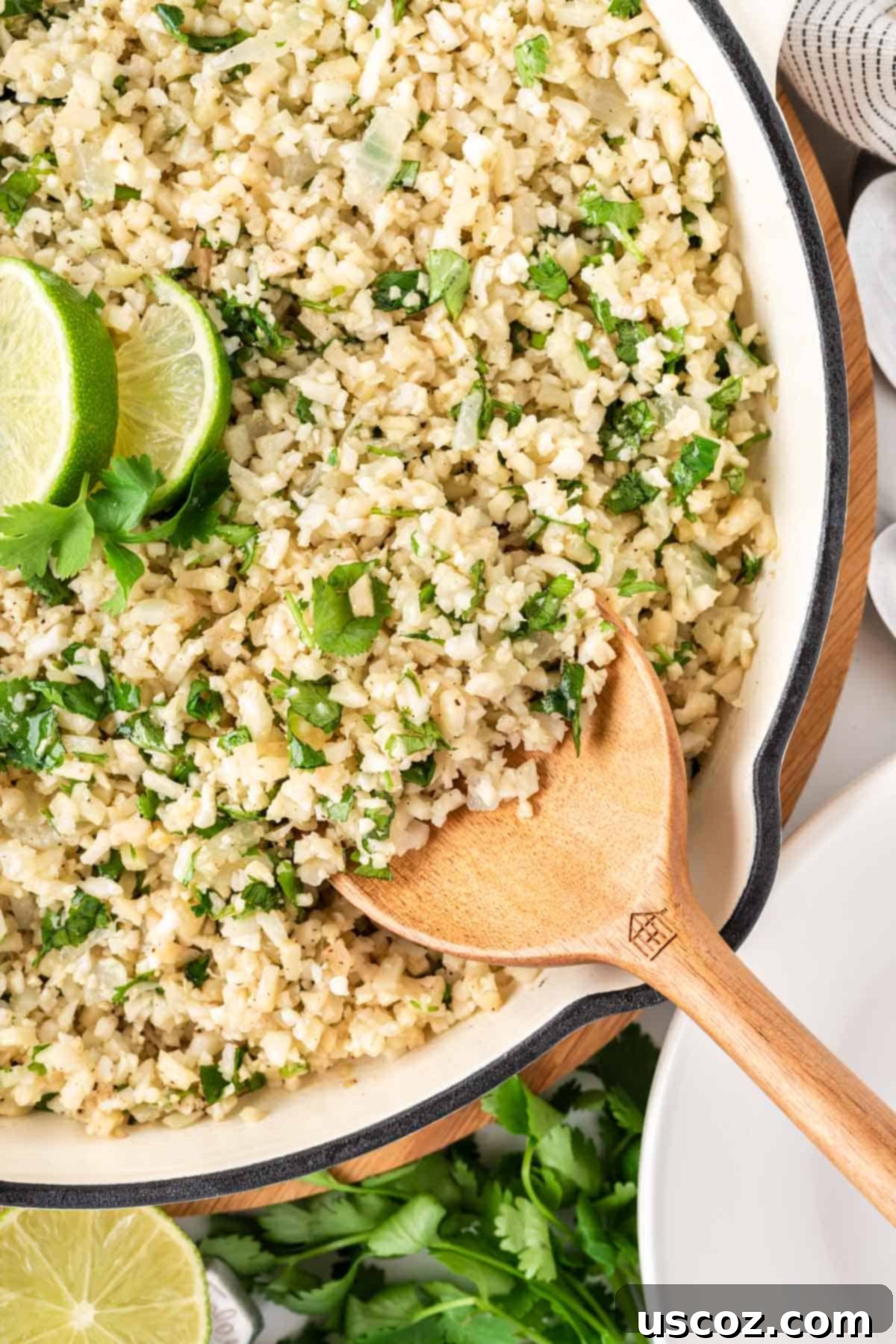Zesty Cilantro Lime Cauliflower Rice 4 Close-up of fluffy cilantro lime cauliflower rice cooking in a non-stick skillet on a stovetop.
