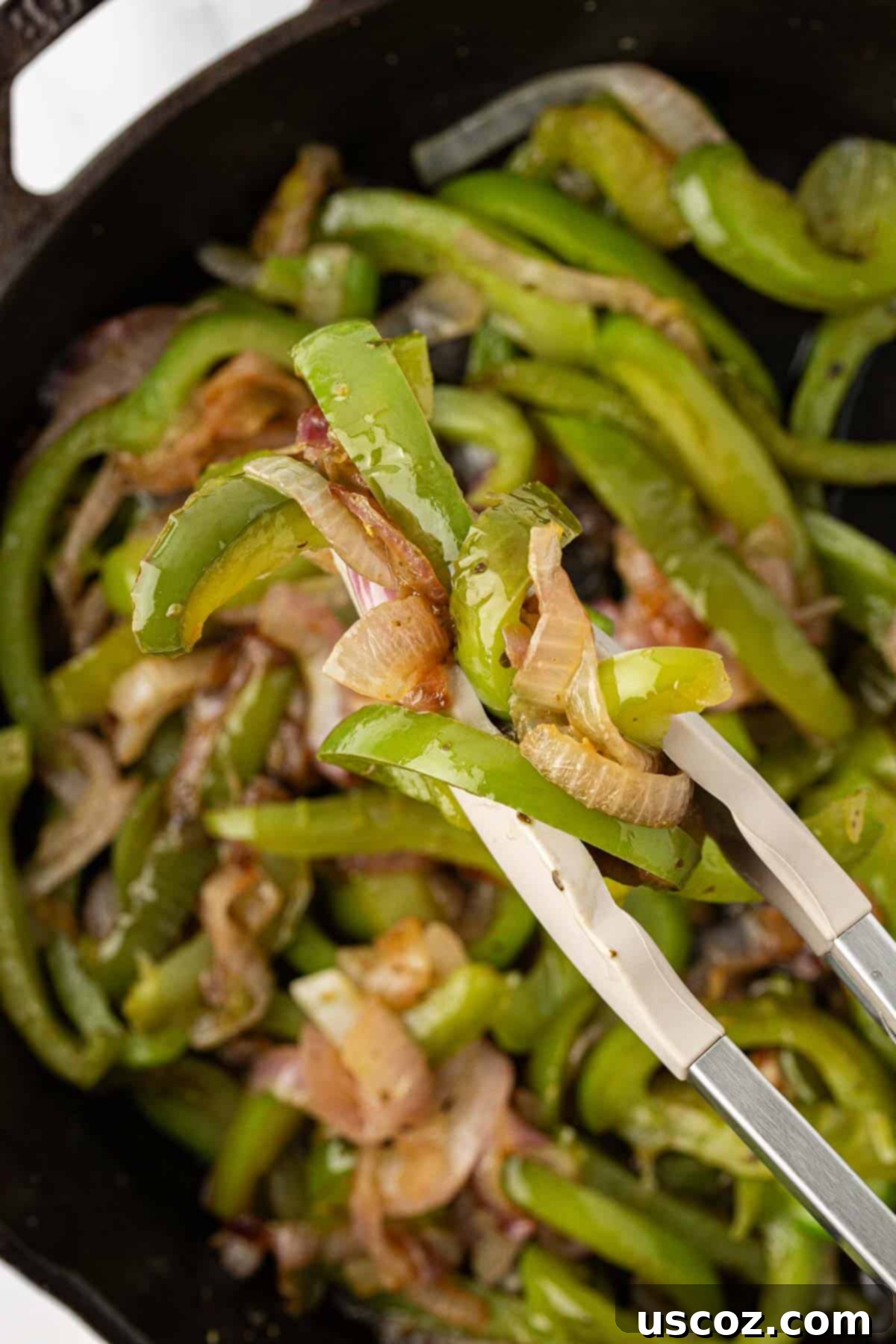 Sizzling Fajita Vegetables 3 A close-up of a spatula scooping hot, perfectly cooked fajita veggies from a skillet, showing their vibrant color and slight char.