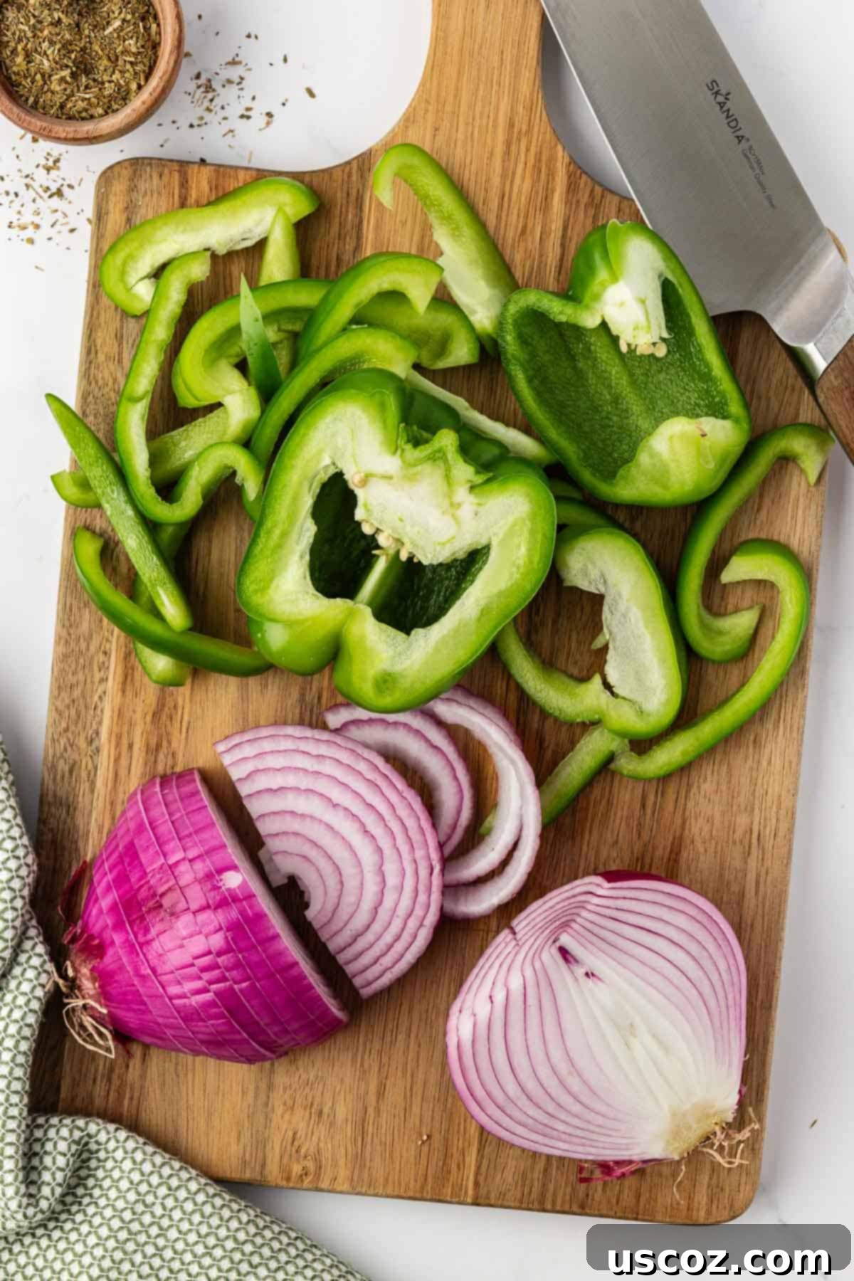 Sizzling Fajita Vegetables 5 Freshly cut green bell pepper strips and red onion slices on a wooden cutting board, prepped for cooking.