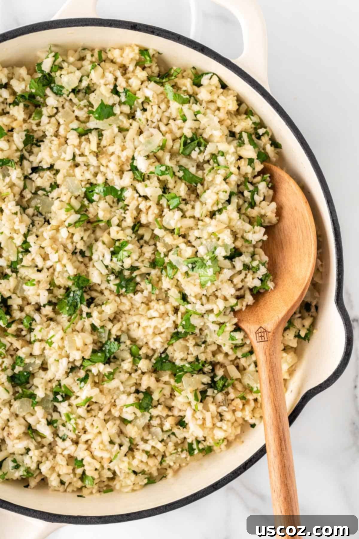 Low-Carb Cauliflower Rice Burrito Bowl 7 Stirring cilantro lime cauliflower rice in a pan, steaming gently