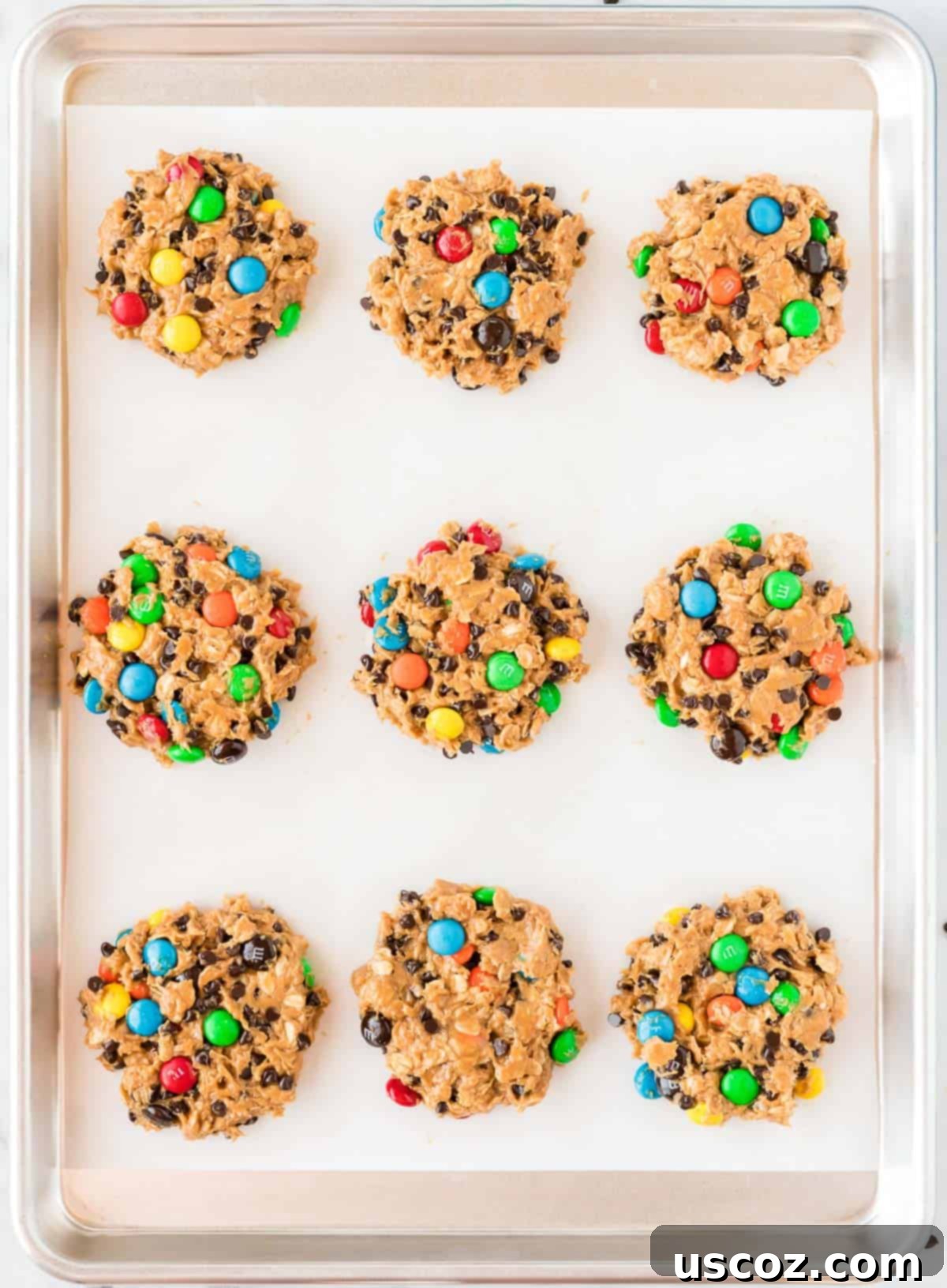 Irresistible Gluten-Free Monster Cookies 11 Raw gluten-free monster cookie dough balls, topped with extra M&M's, arranged on a baking sheet