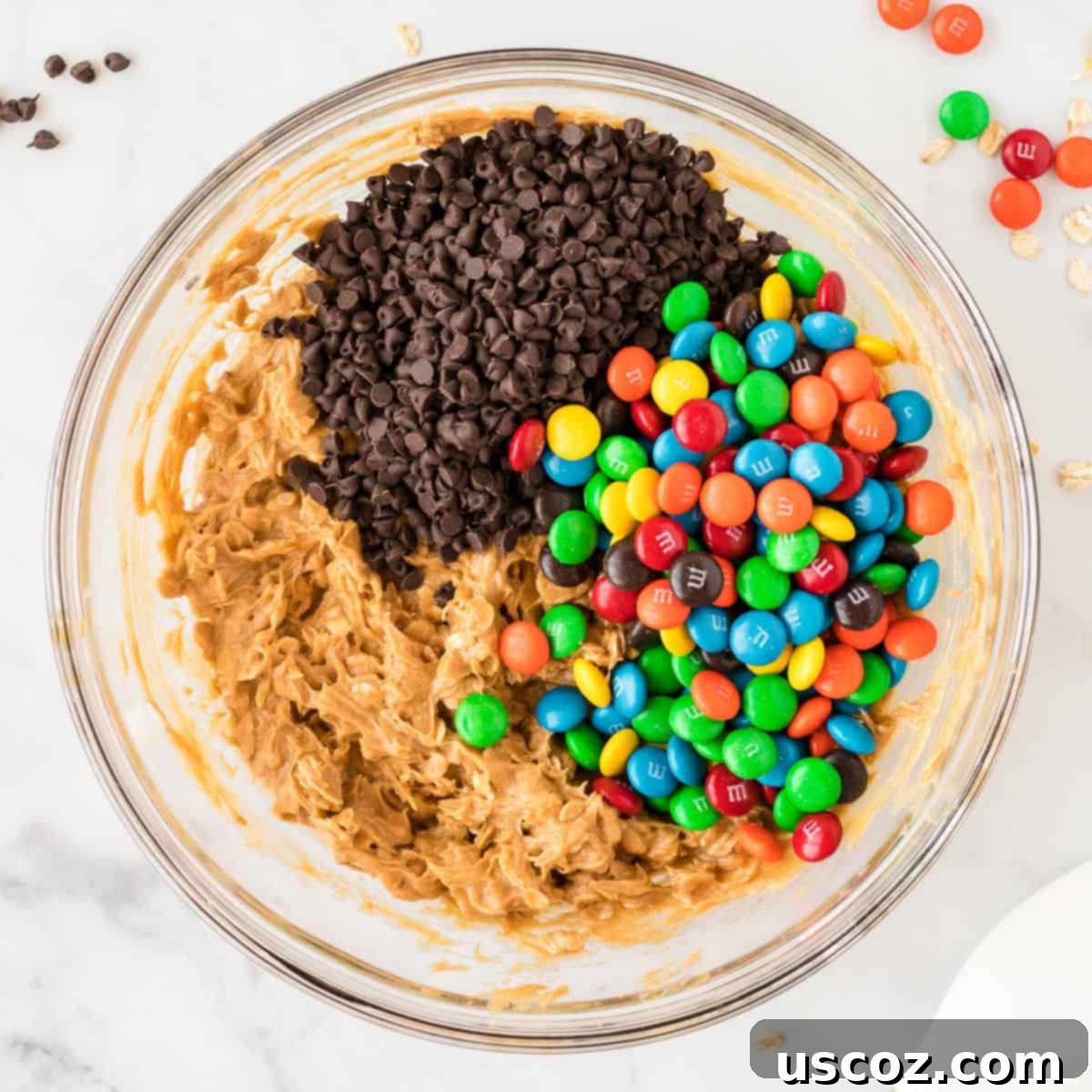 Irresistible Gluten-Free Monster Cookies 9 Mini chocolate chips and colorful M&M's are being folded into the gluten-free monster cookie batter.