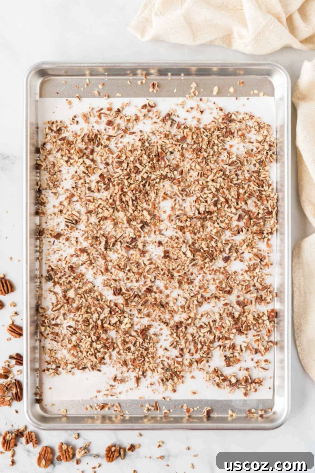 Velvet Pecan Delight 4 Close-up of chopped pecans spread on a baking sheet, ready for toasting.