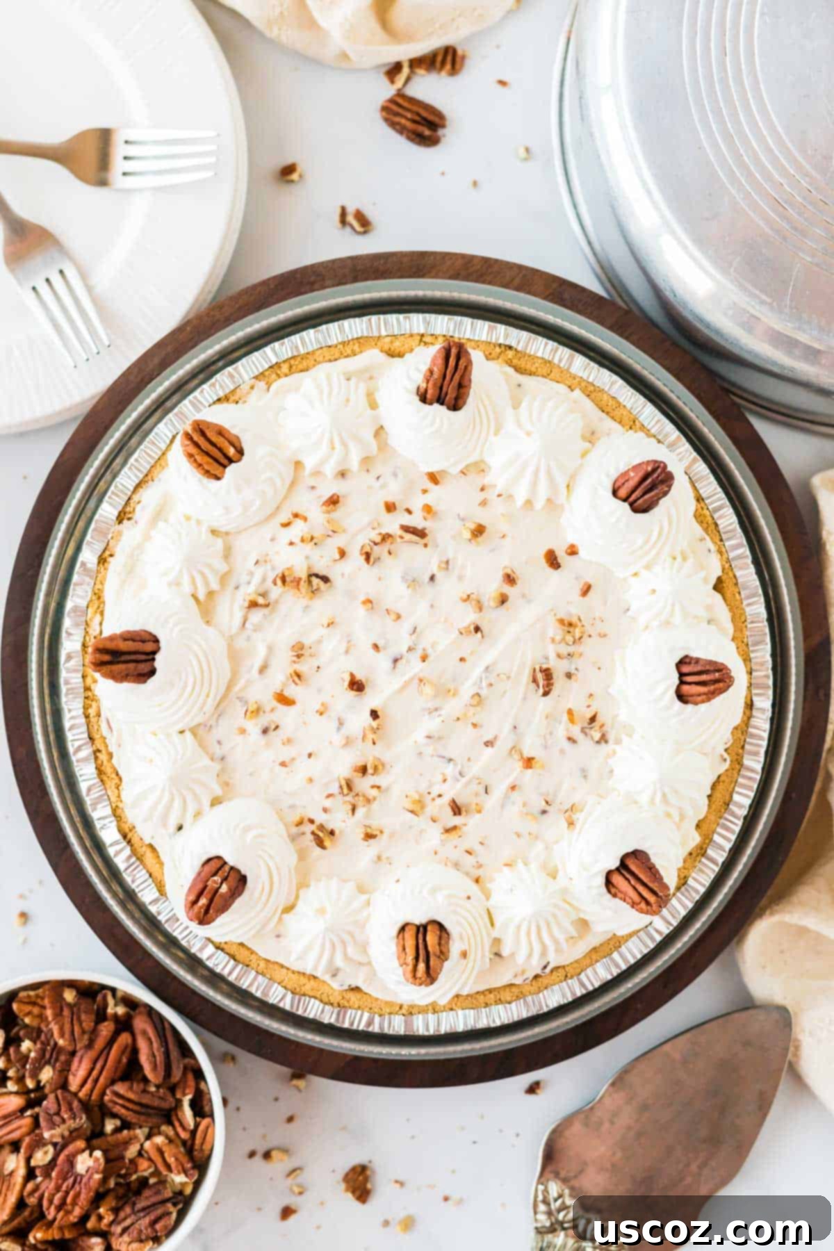 Velvet Pecan Delight 7 A stunning pecan cream cheese pie topped with a generous swirl of whipped cream and chopped pecans, ready to be served.