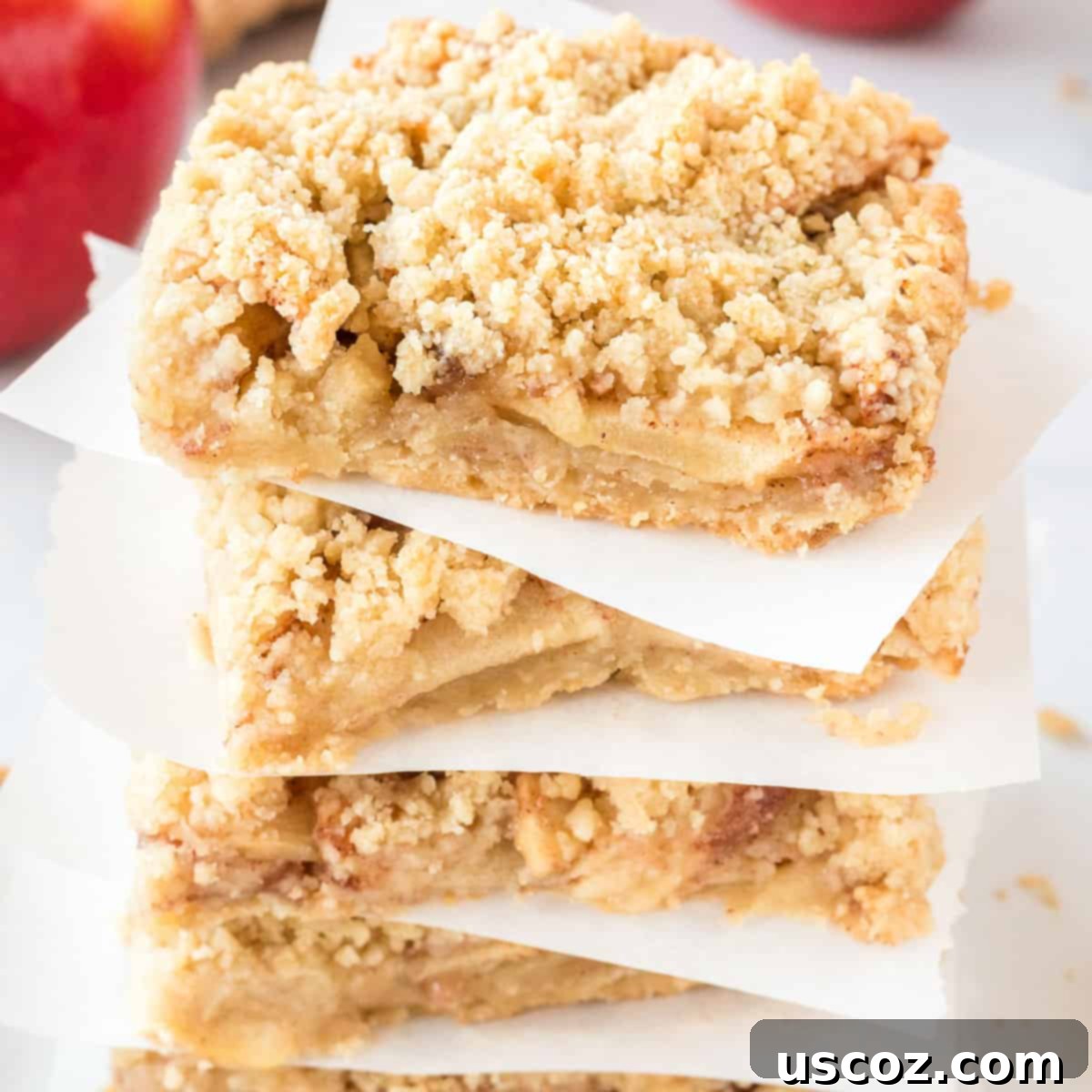 Cinnamon Apple Crumble Bars 2 Stacked homemade apple crisp bars on parchment paper