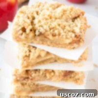 Cinnamon Apple Crumble Bars 14 Stacked homemade apple crisp bars on parchment paper