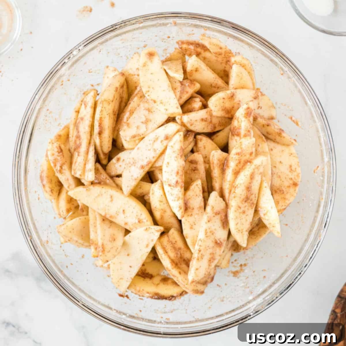 Cinnamon Apple Crumble Bars 5 Thinly sliced apples mixed with cinnamon and sugar in a bowl