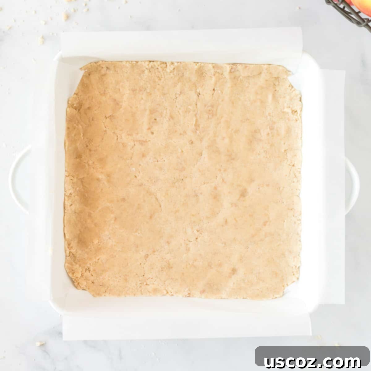Cinnamon Apple Crumble Bars 7 Baked shortbread crust in an 8x8 baking dish, golden brown