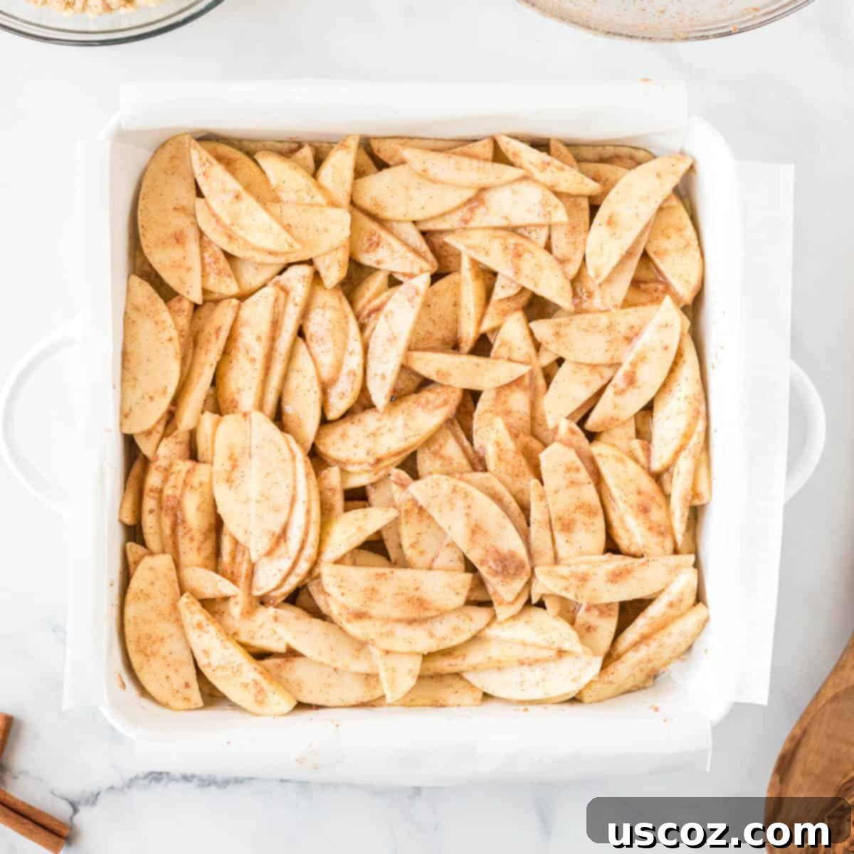 Cinnamon Apple Crumble Bars 8 Spiced apple filling spread over the shortbread crust in a baking dish