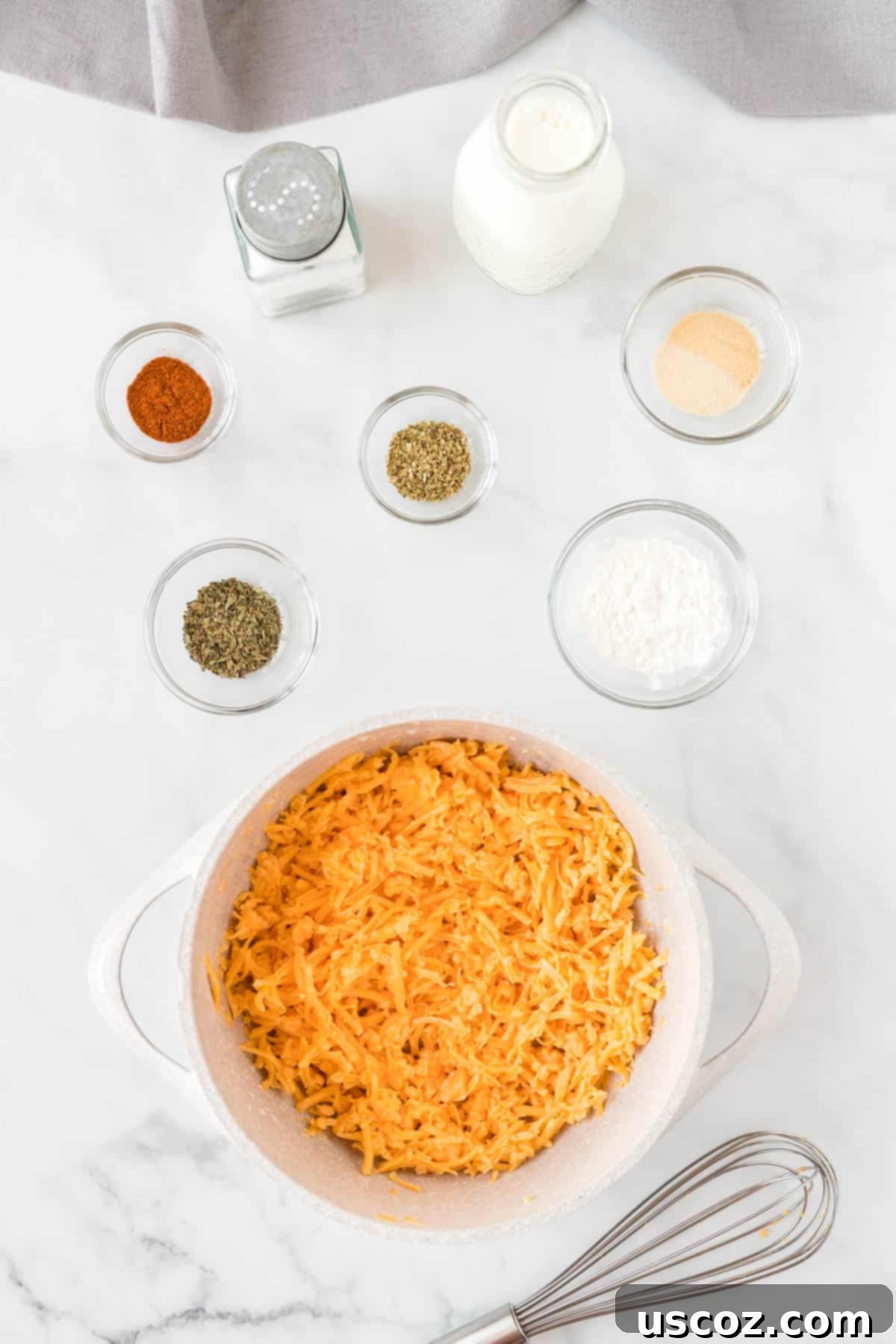 Golden Cheesy Cauliflower 6 Various cheese sauce ingredients, including milk, spices, and grated cheddar cheese, simmering and being stirred in a saucepan on the stovetop.