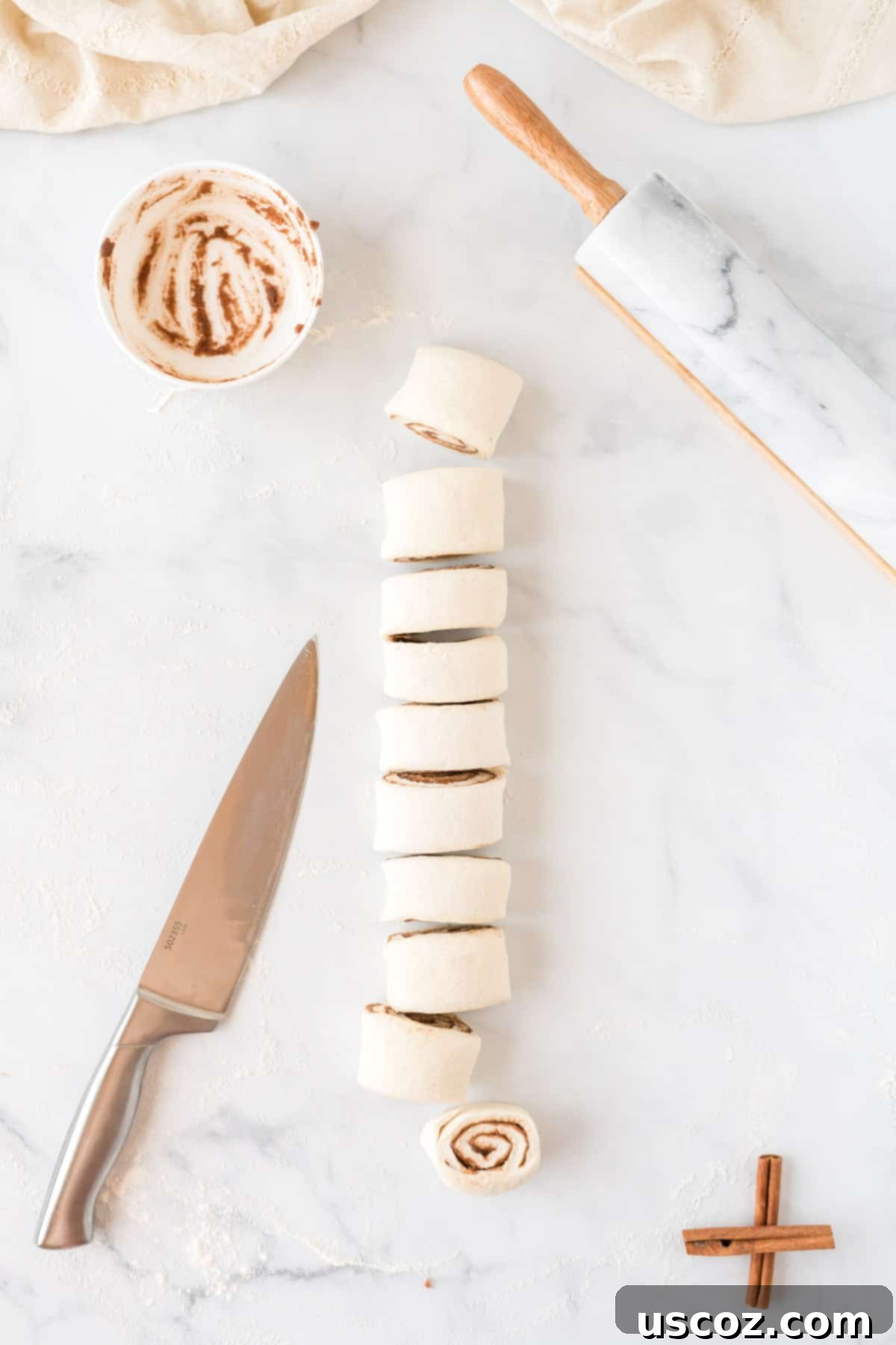 Effortless Cinnamon Swirls 10 cinnamon roll dough log cut into individual pieces, ready for baking