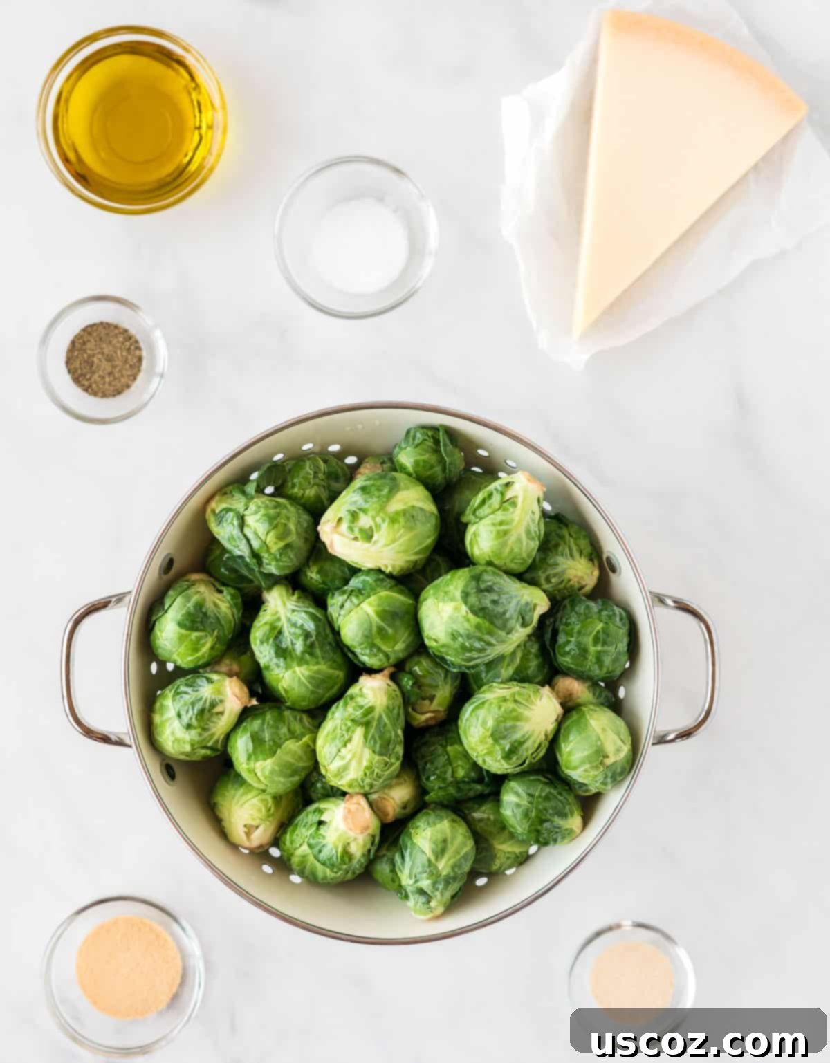 Parmesan Roasted Brussels Sprouts 4 ingredients needed to make parmesan brussels sprouts laid out on a wooden board