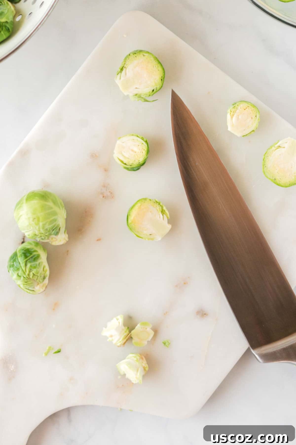 Parmesan Roasted Brussels Sprouts 5 cutting brussels sprouts in half on a wooden cutting board