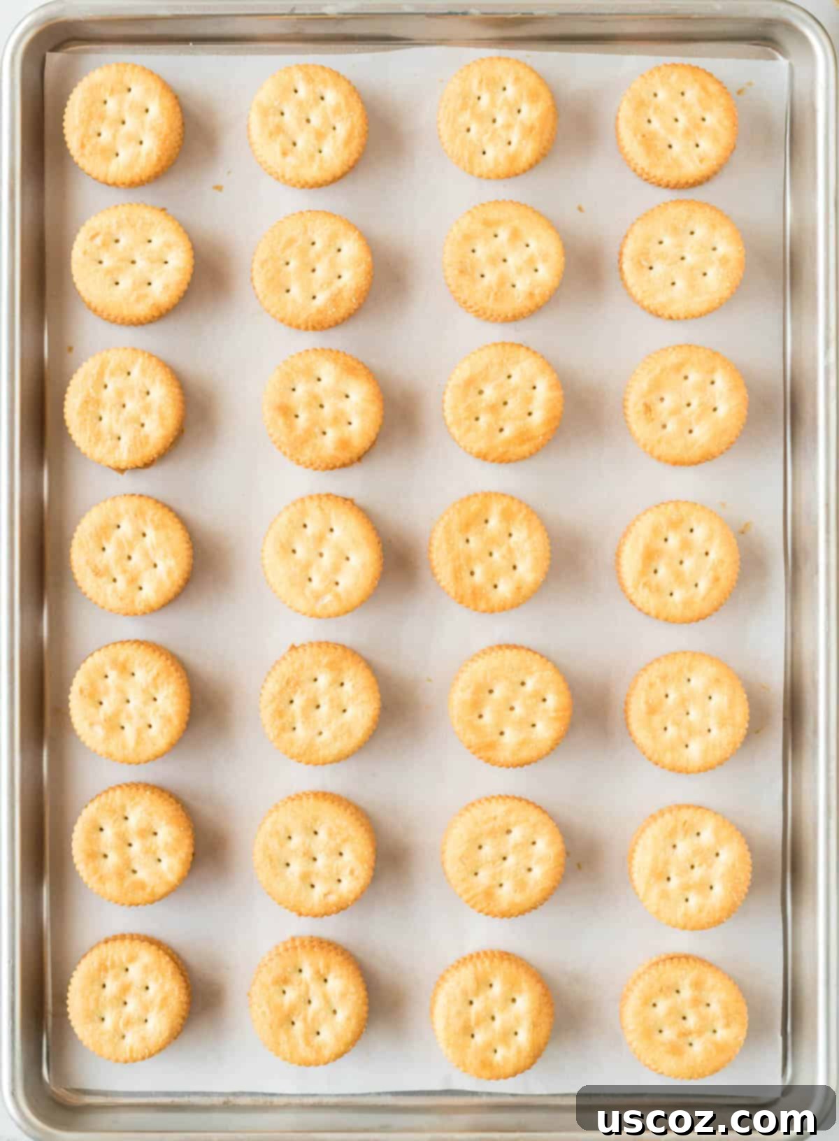 Irresistible Ritz Cookie Bites 7 Peanut butter Ritz cracker sandwiches assembled on a baking sheet, ready for dipping.