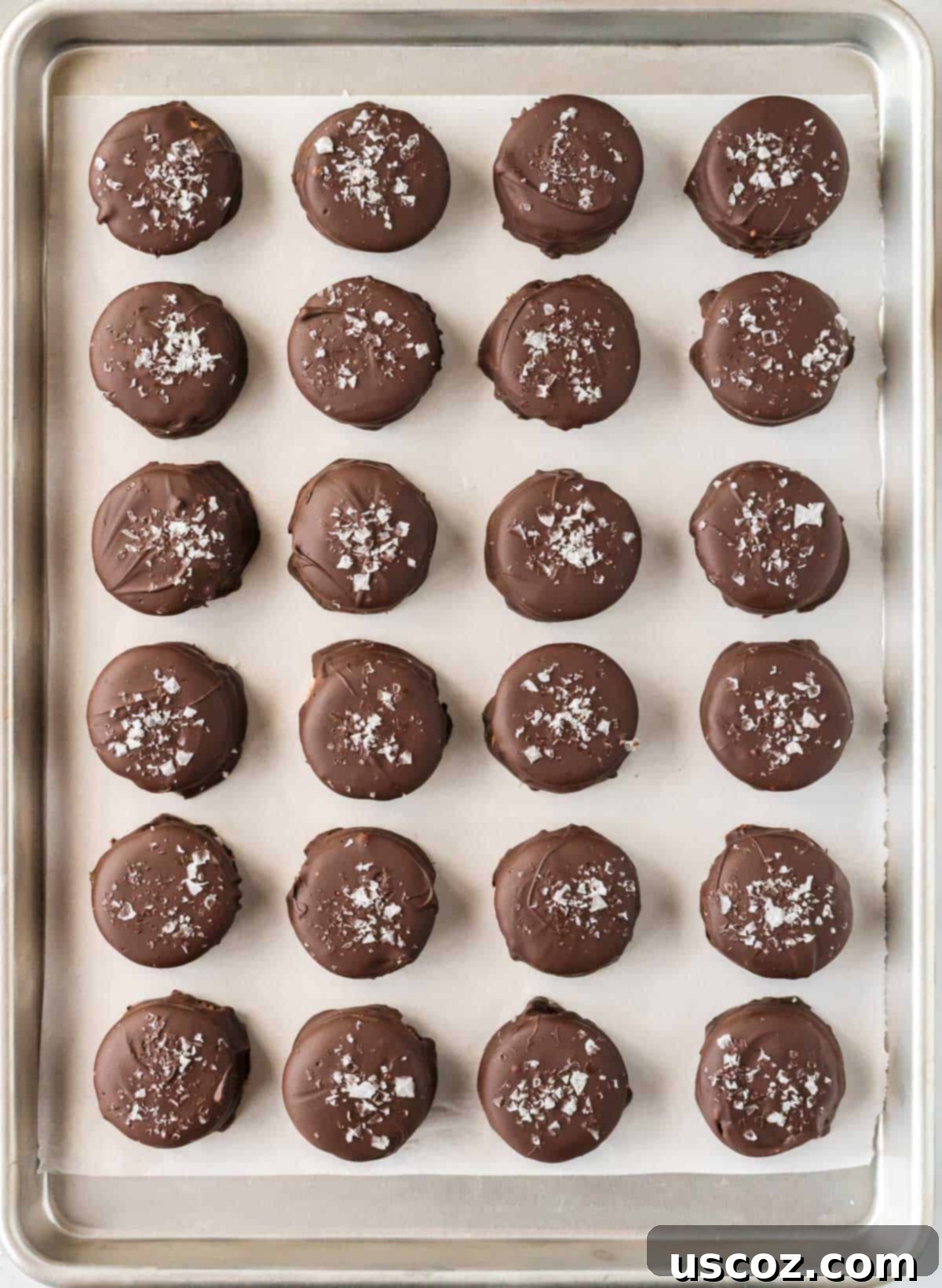 Irresistible Ritz Cookie Bites 8 A finished chocolate-dipped Ritz Cracker Cookie on a fork, ready to be placed on a baking sheet.