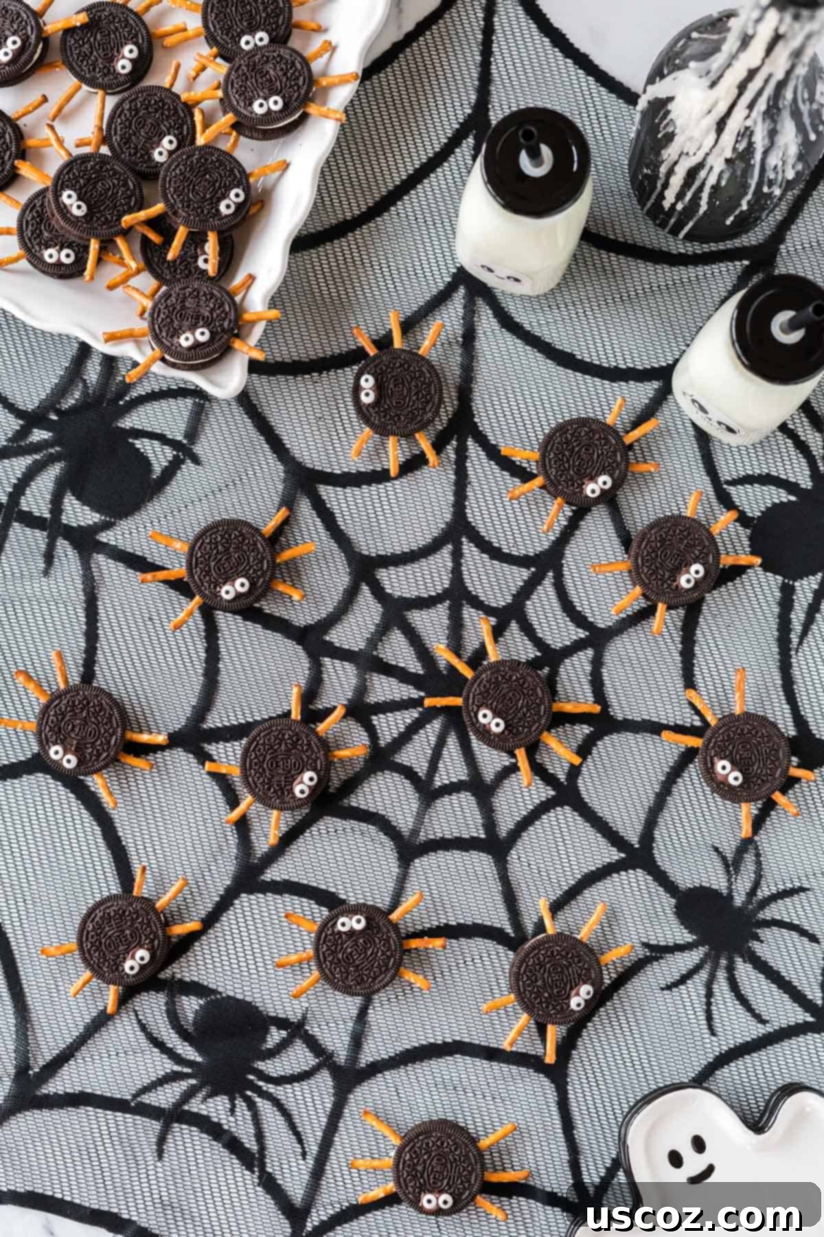 Eight-Legged Oreo Delights 11 Oreo spider cookies with pretzel legs and googly eyes arranged on a black serving platter with a cobweb design.