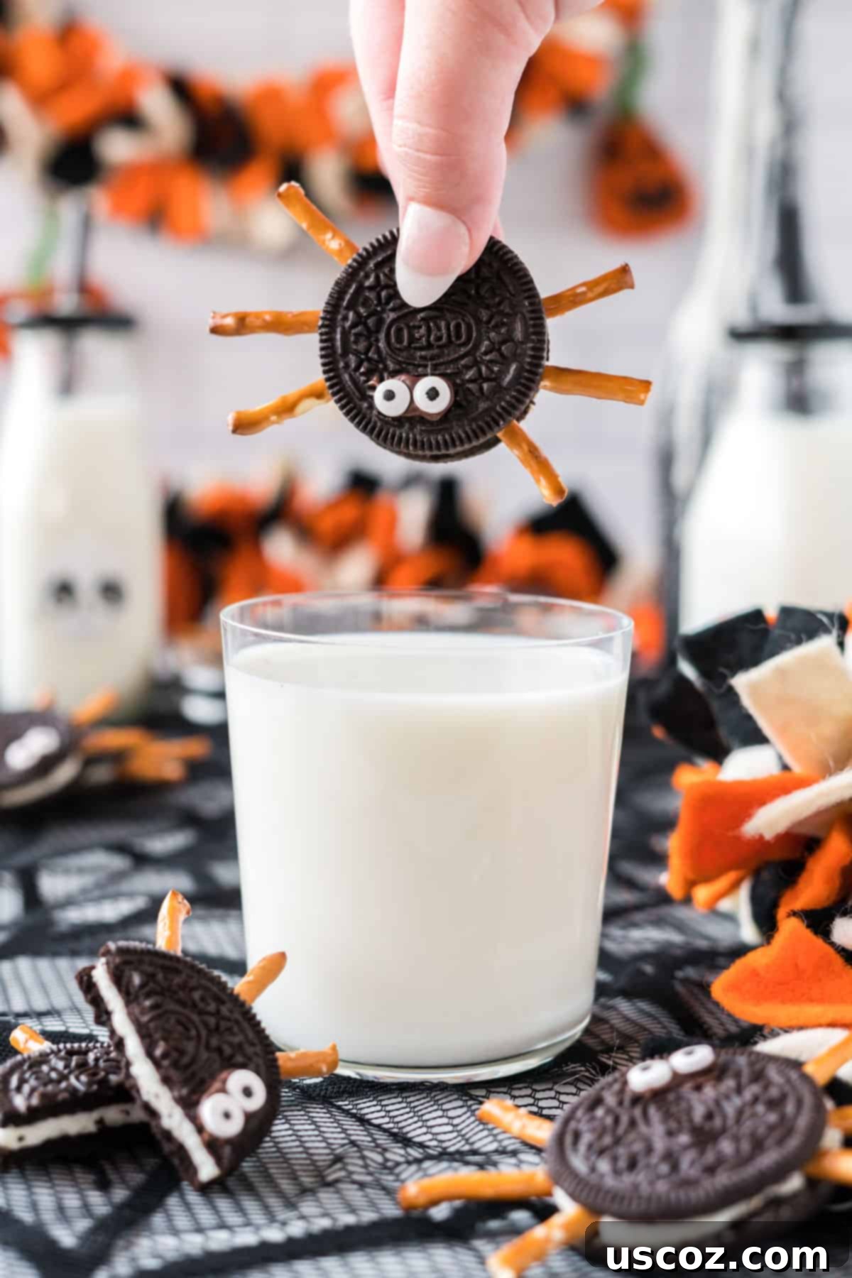 Eight-Legged Oreo Delights 15 A finished Oreo spider cookie sitting on the rim of a glass of milk, inviting a delicious dip, perfect for a Halloween snack.