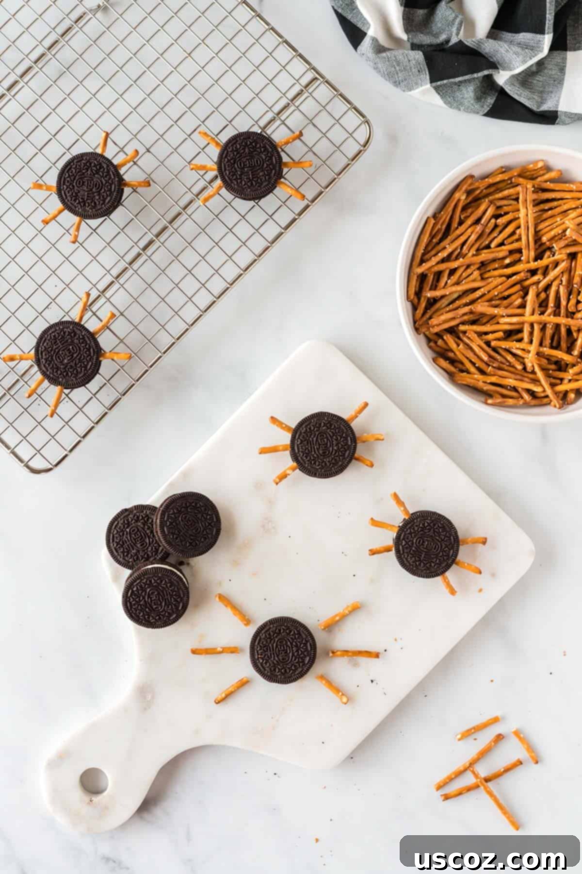 Eight-Legged Oreo Delights 5 Close-up of a hand carefully placing pretzel rods into the creamy filling of an Oreo cookie to form spider legs.