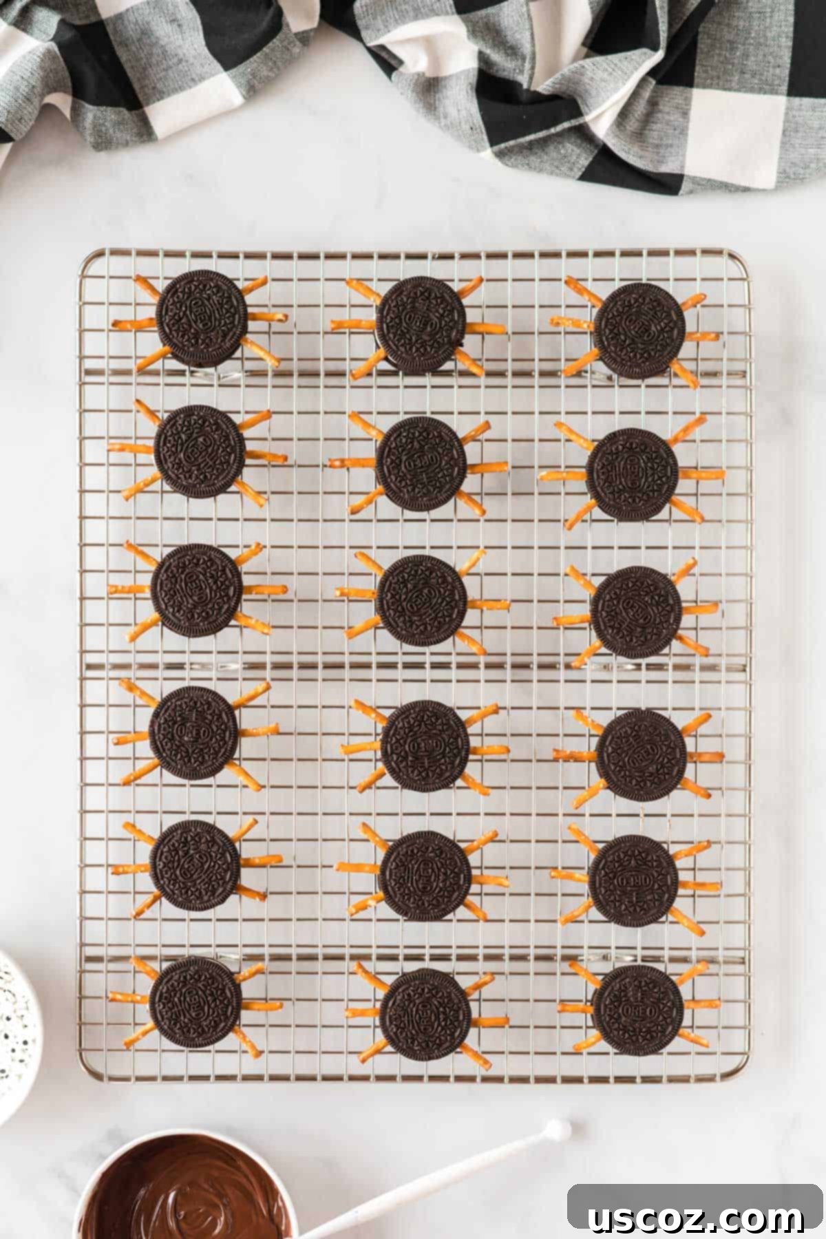 Eight-Legged Oreo Delights 8 Several Oreo cookies already fitted with pretzel rod legs, ready for their googly eyes to complete the spider look.