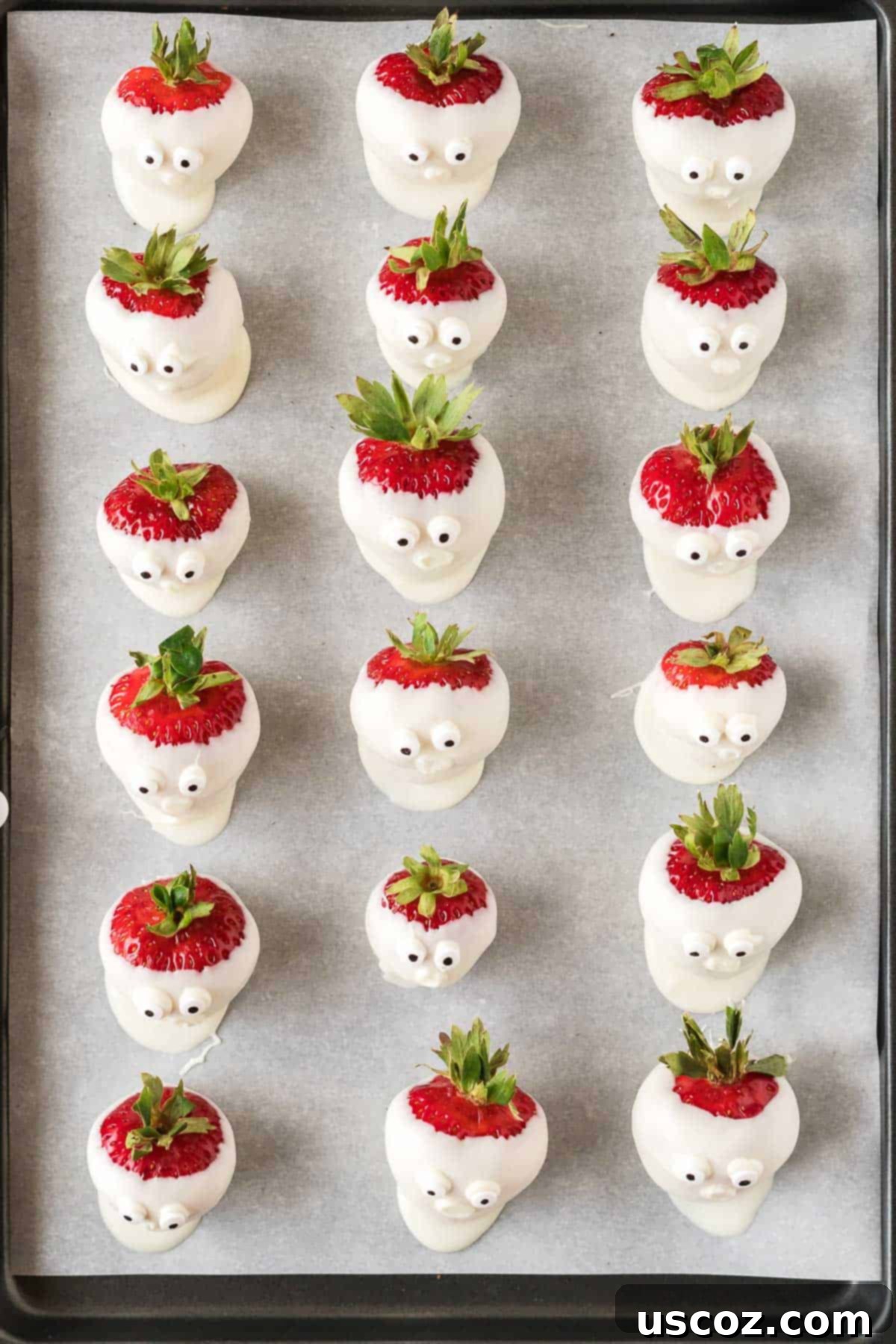 Strawberry Whispers 10 strawberry ghosts with candy eye balls on a baking sheet
