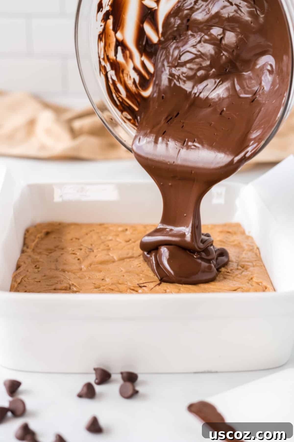 Effortless Protein Bars 13 pouring the melted chocolate over the top of the protein bar filling