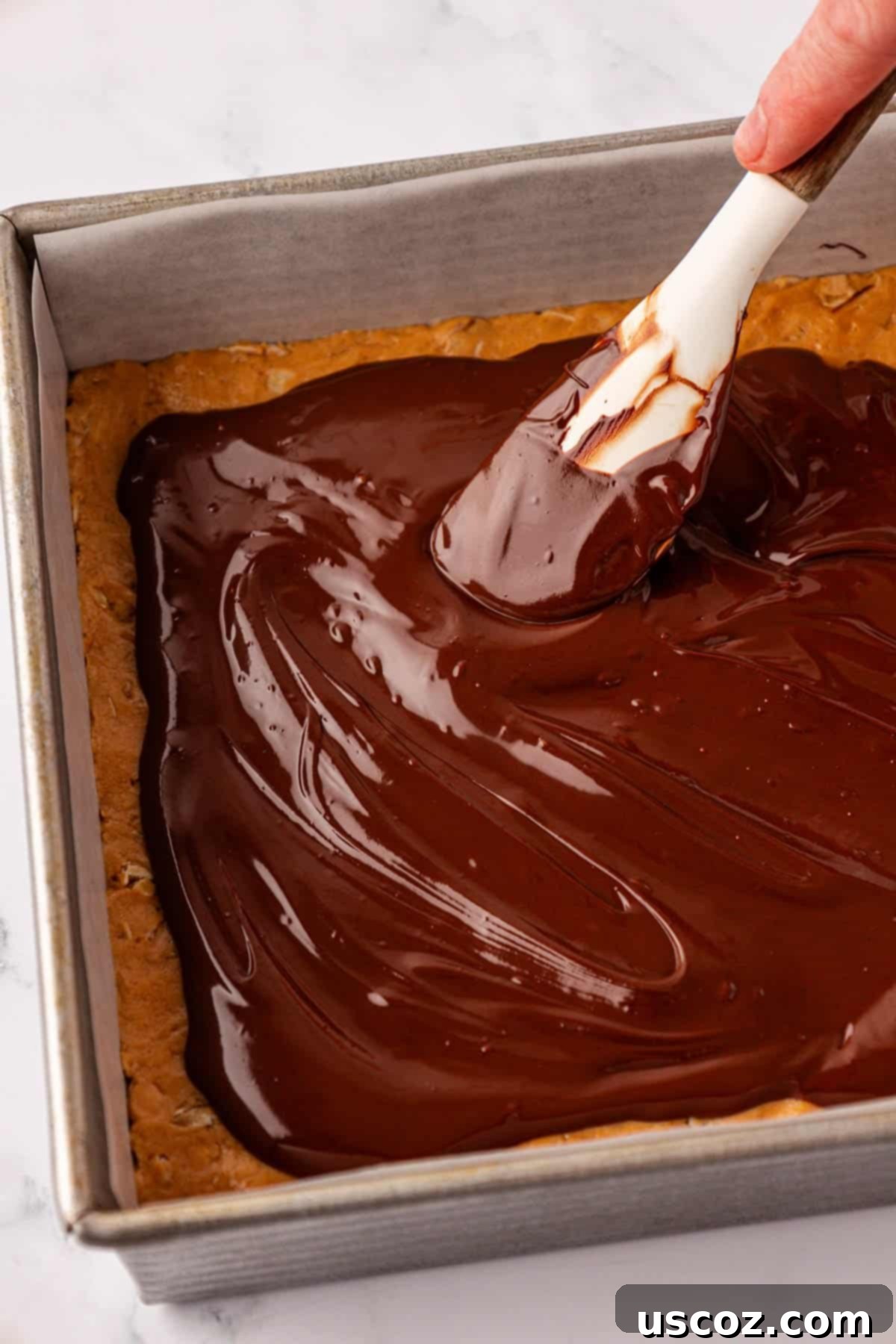 Effortless Protein Bars 14 spreading the melted chocolate over the protein bars