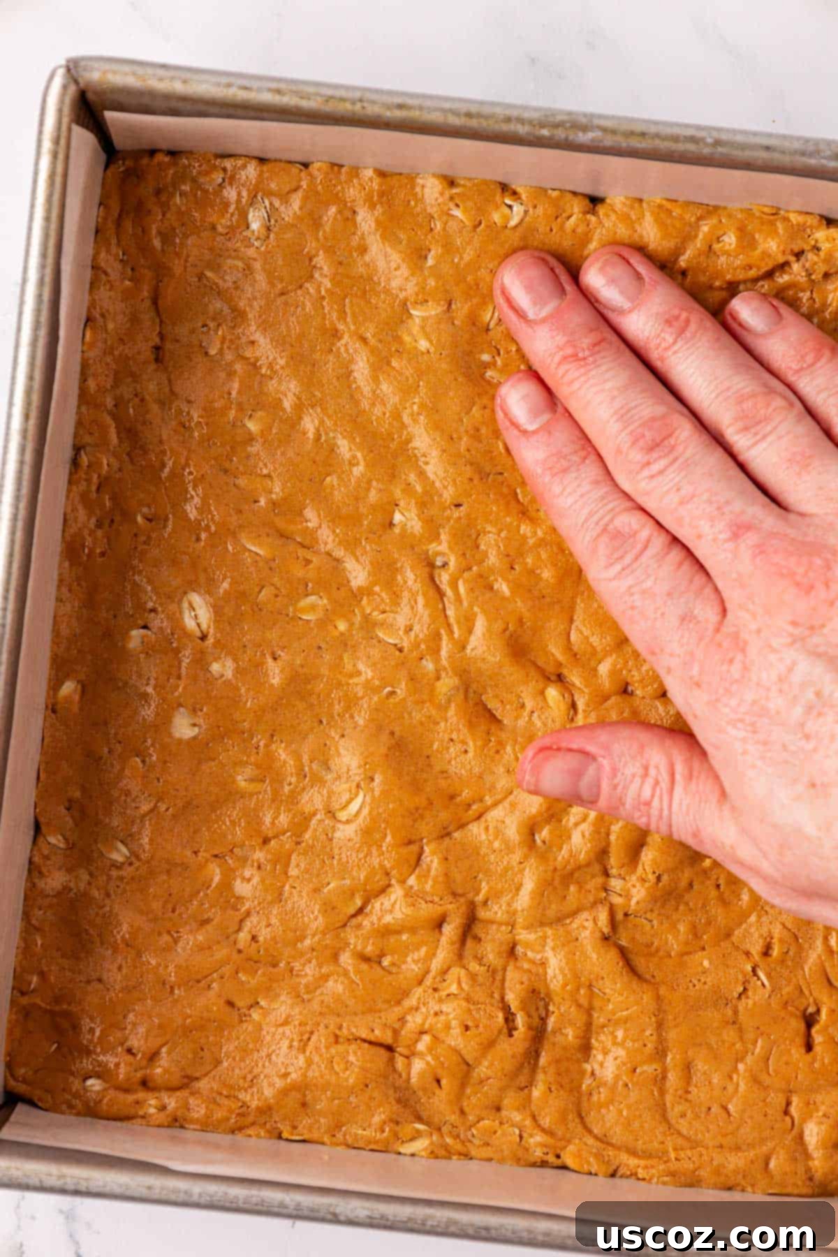Effortless Protein Bars 9 pressing the protein bar batter into a pan