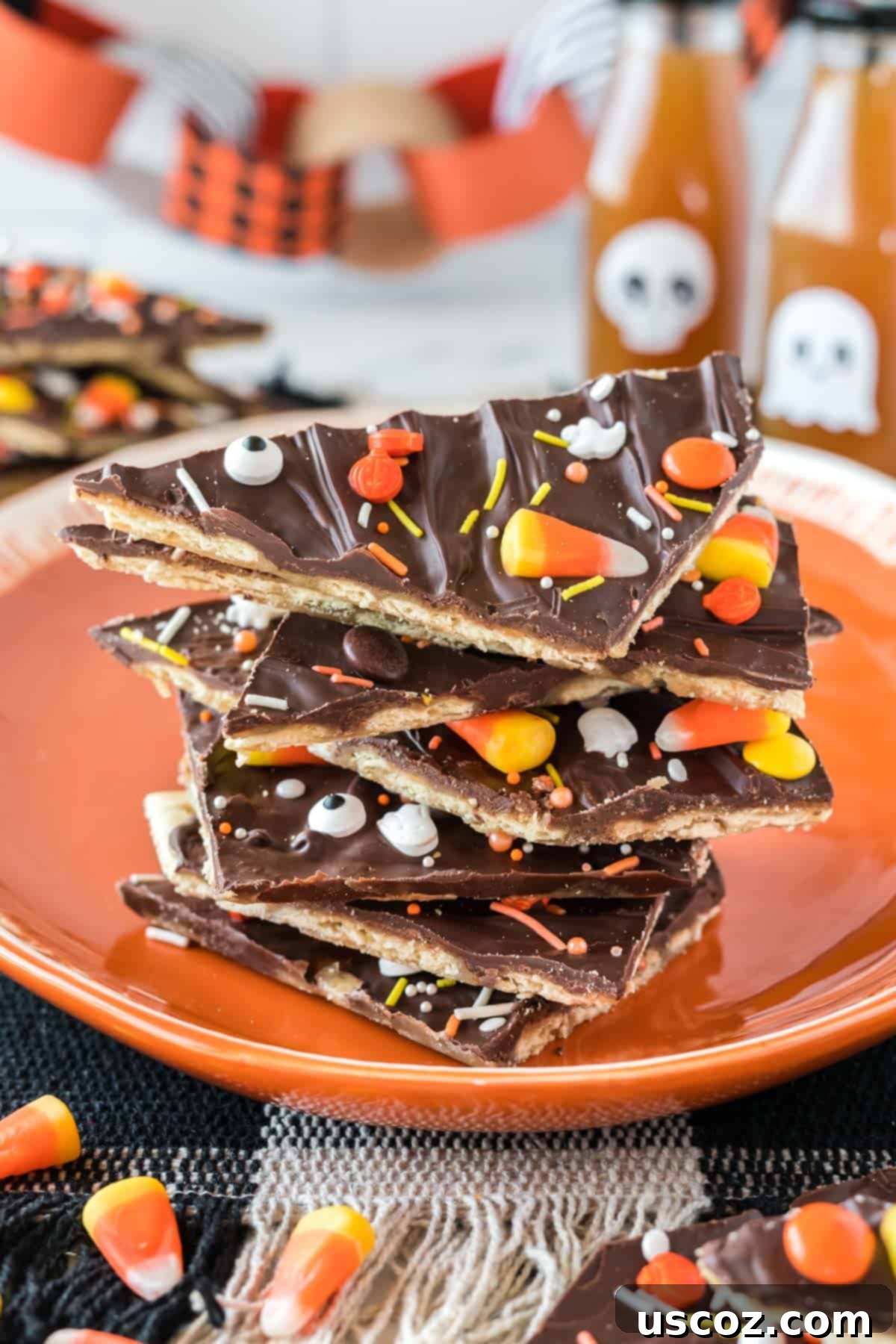 Spooky Halloween Crack 2 Halloween crack candy pieces stacked on an orange plate, showcasing the spooky sprinkles and melted chocolate.