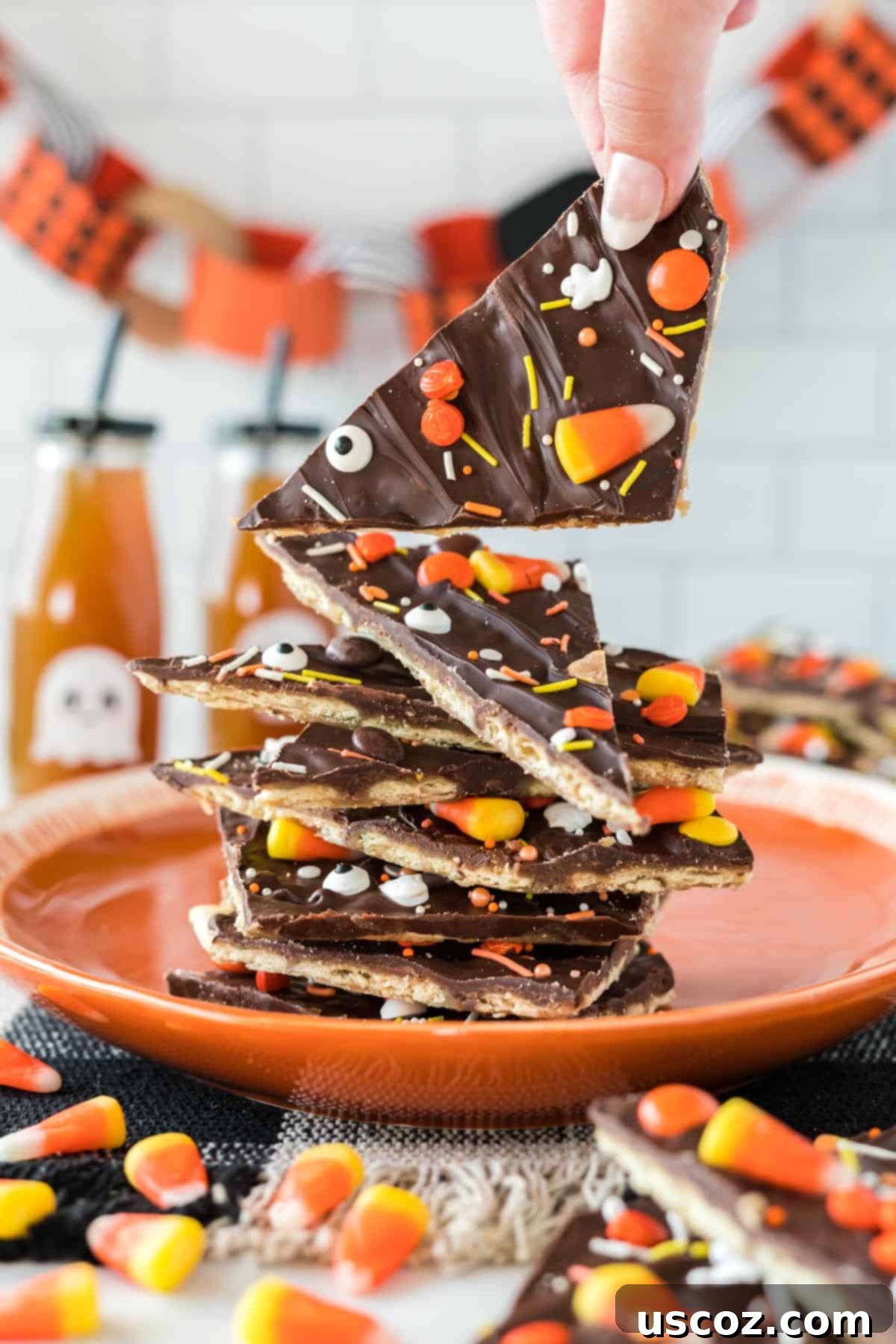 Spooky Halloween Crack 14 More Halloween crack candy pieces stacked on an orange plate, showing off different angles.